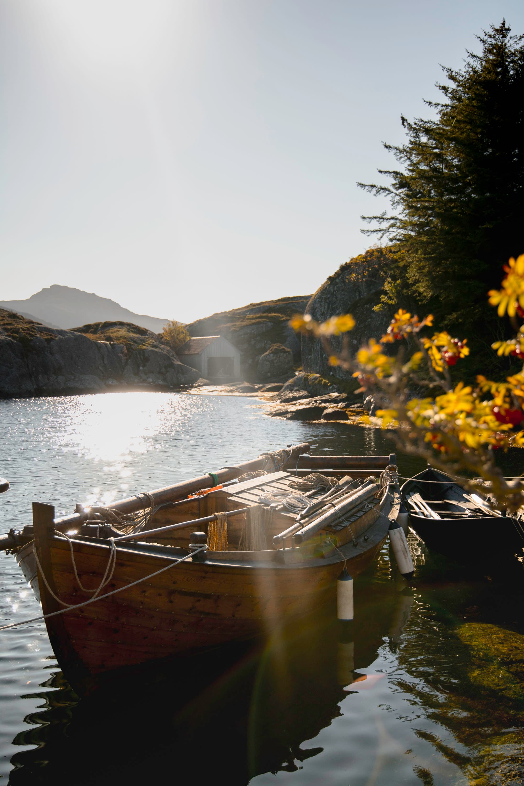 en robåt som ligger fortøyd på sjøen. det er sol