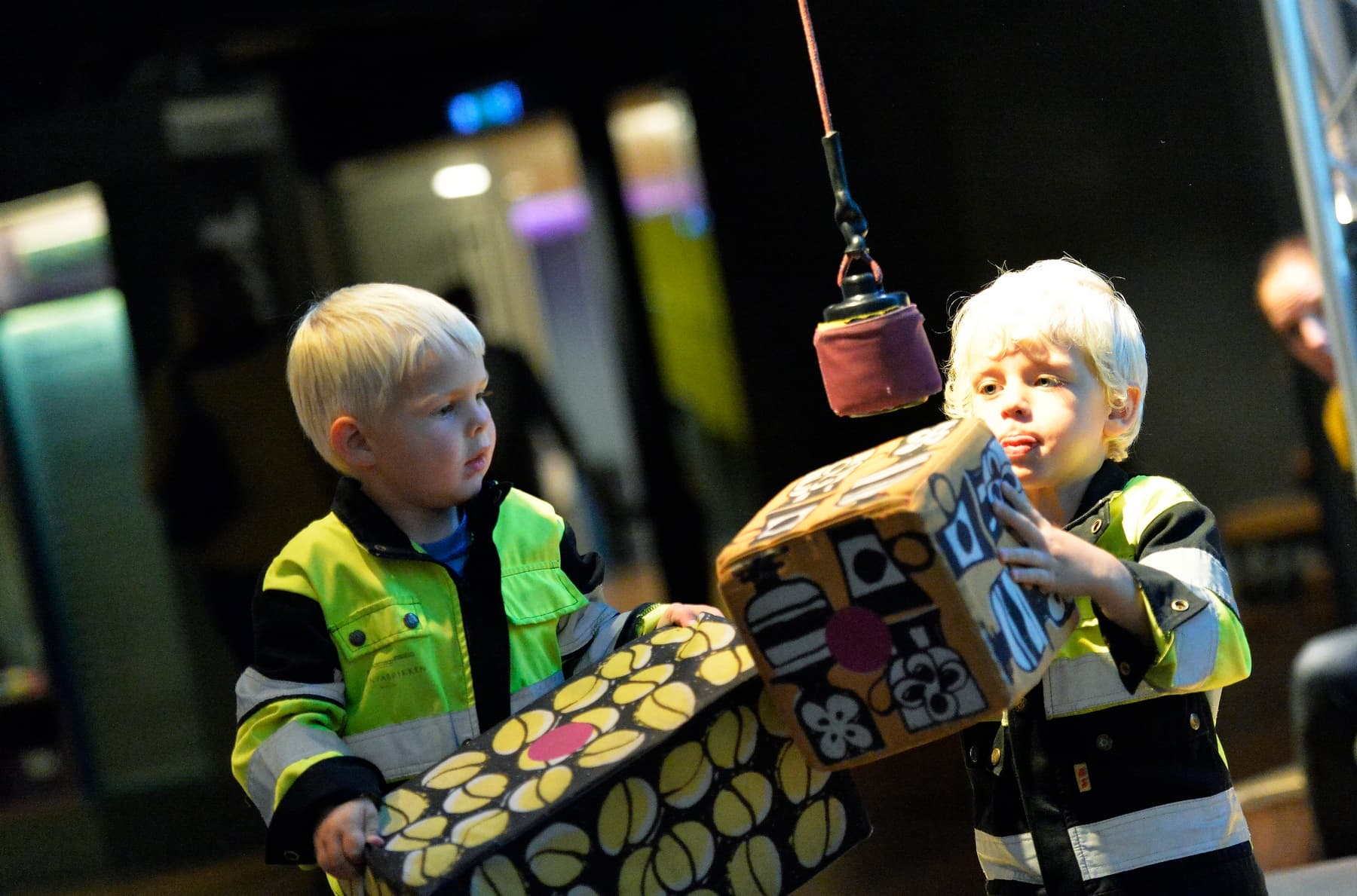 To barn leker med en lekeheisekran på museum.