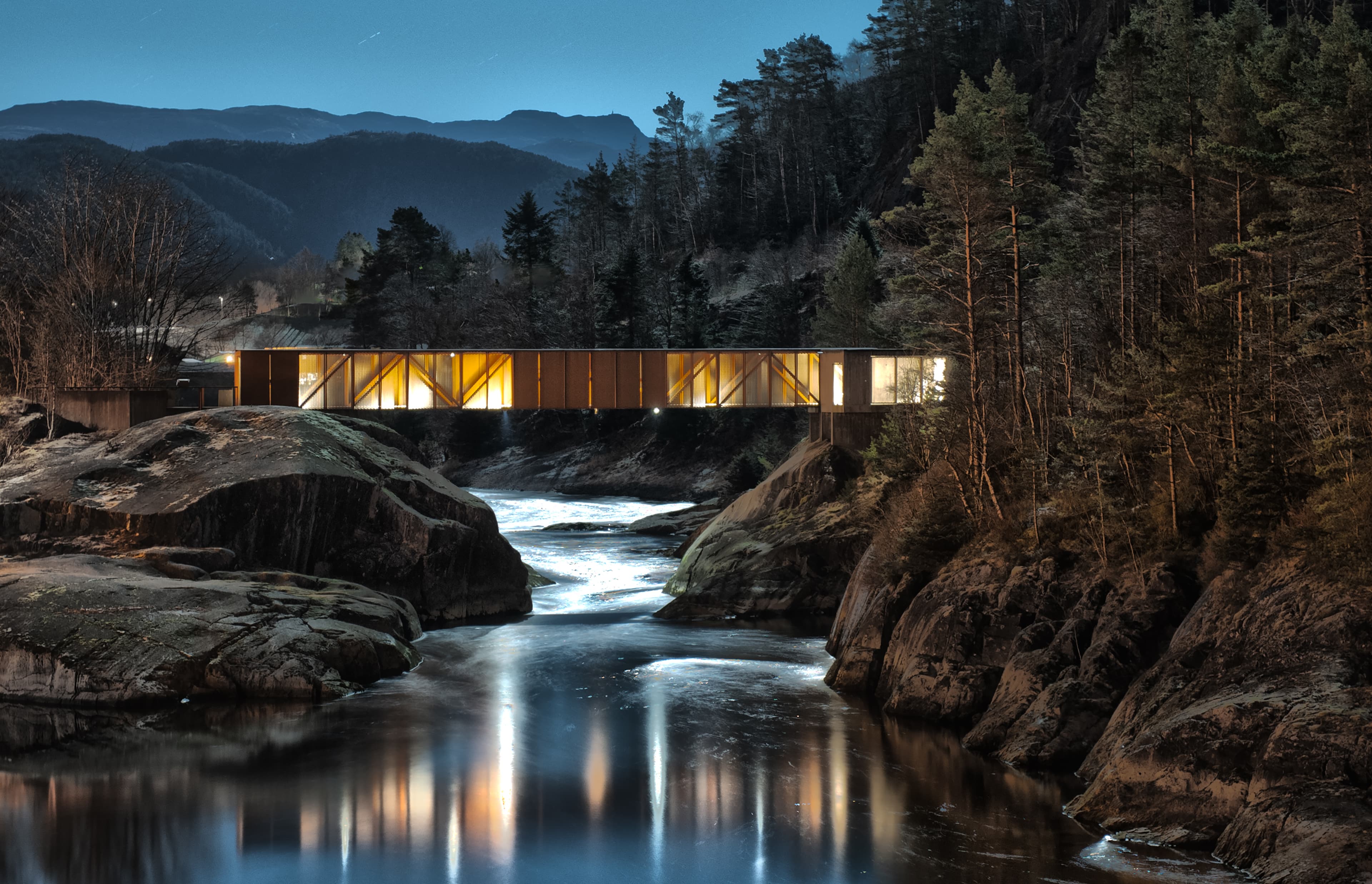 Høsebrua lyser opp Suldalslågen i mørket.