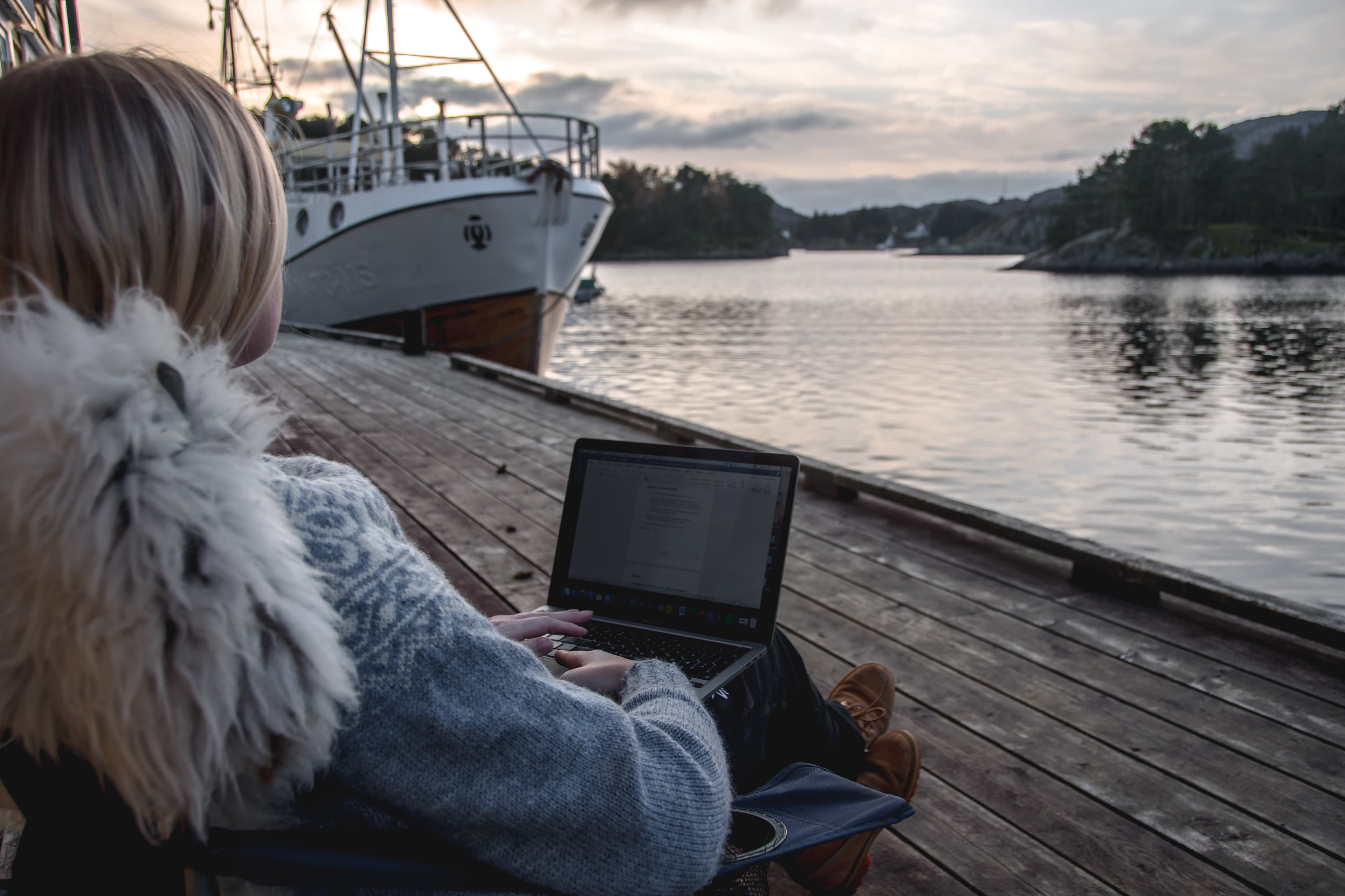 Dame jobber på en datamaskin mens hun nyter utsikt og frisk luft