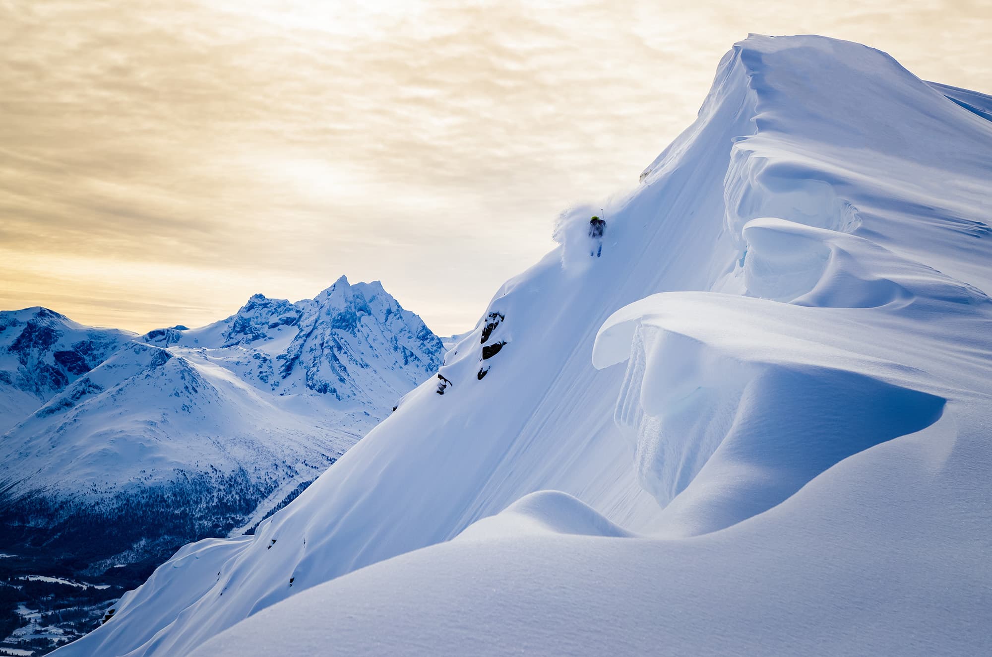 En skiløper som står på ski ned et bratt fjell.
