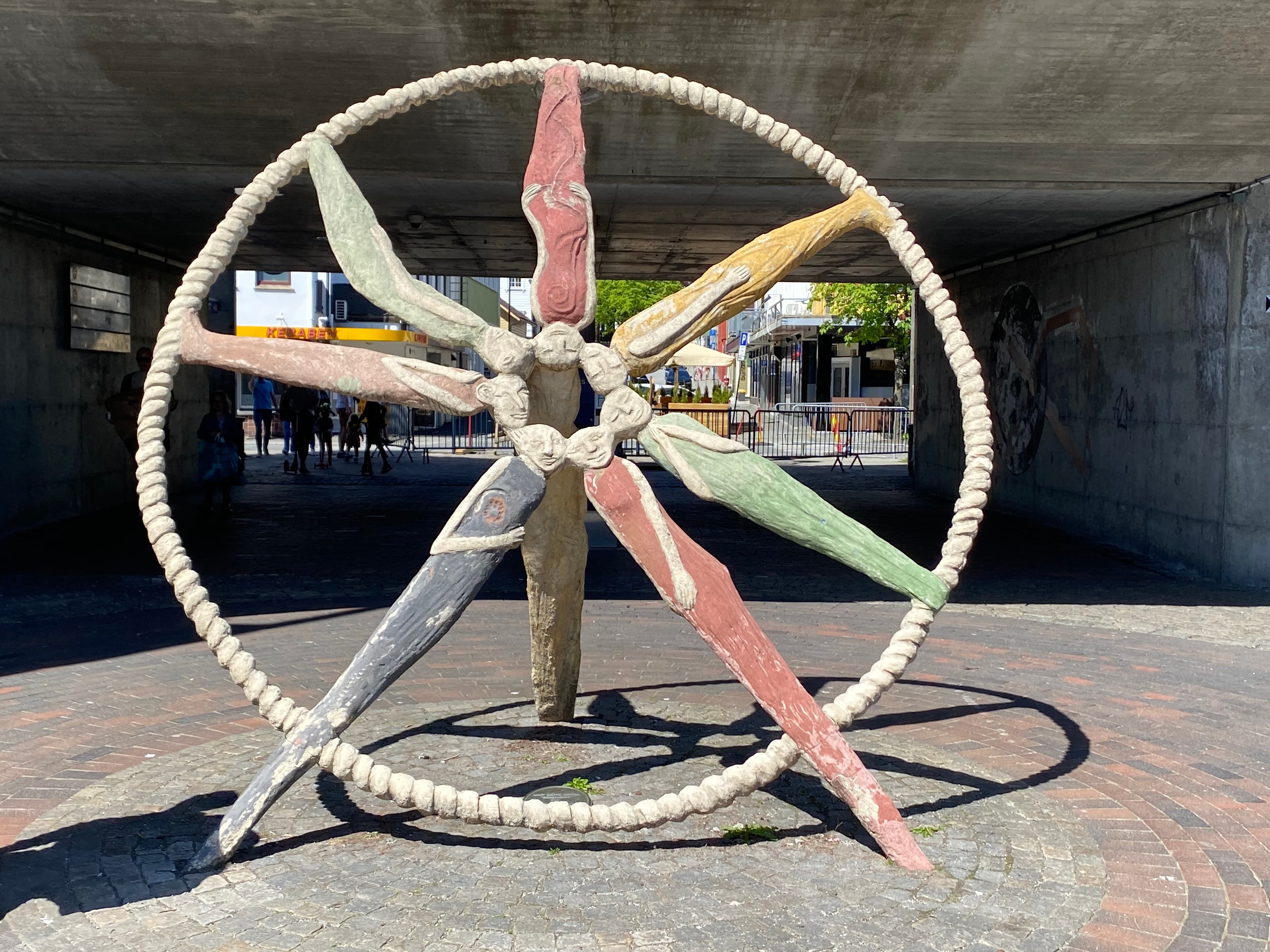 Tankedelere av Marit Benthe Norheim, 1993. I hjertet av Ruten, knutepunkt for kommunikasjon i Sandnes, finner vi et hjul av kolorerte menneskefigurer i et naivistisk formspråk. Symbol på det korte møtet og folk som like etter sprer seg i ulike retninger