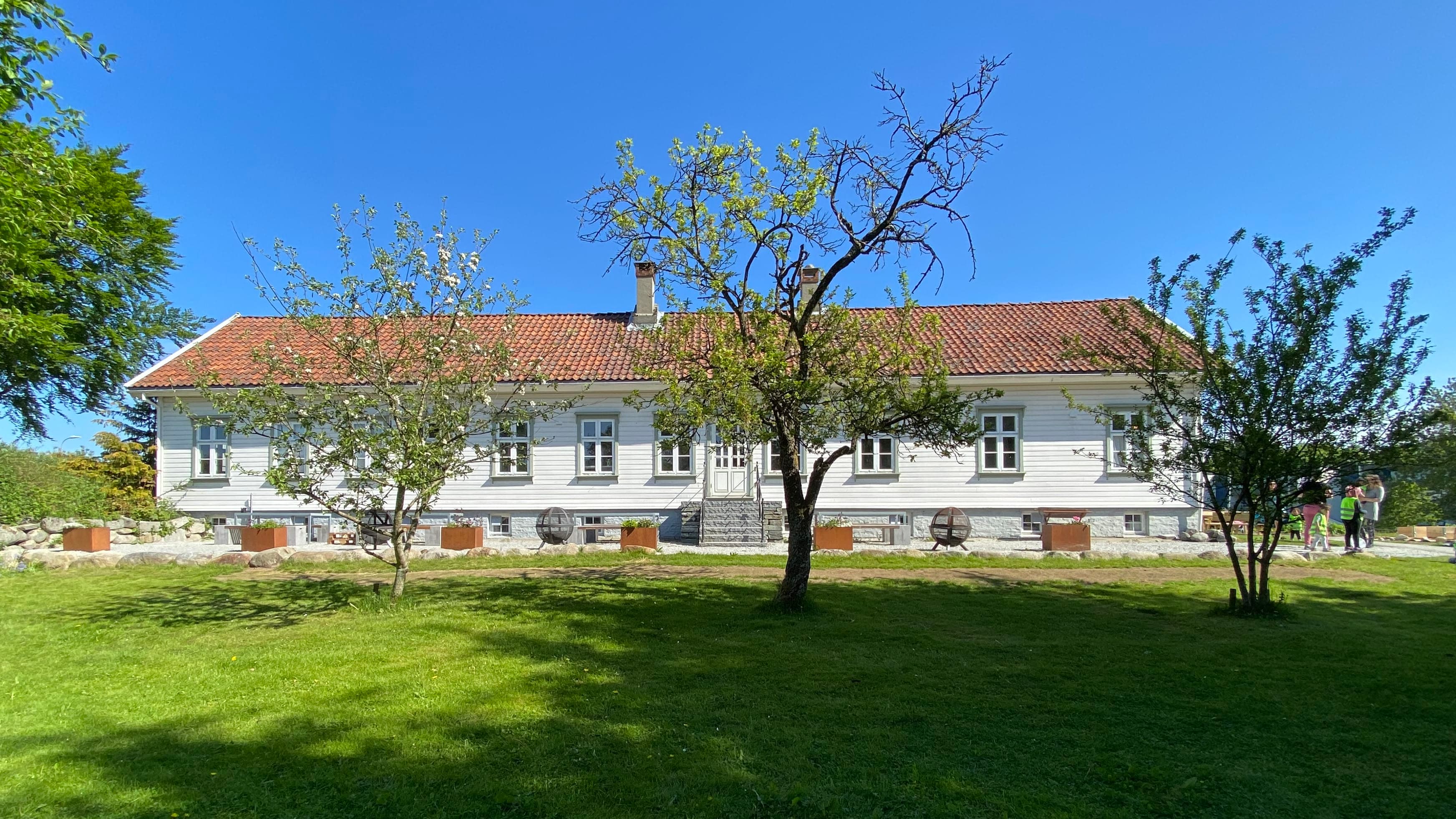 Den store hovedbygningen er et halvannenetasjes sveitserhus med to sidefløyer i en u-form.