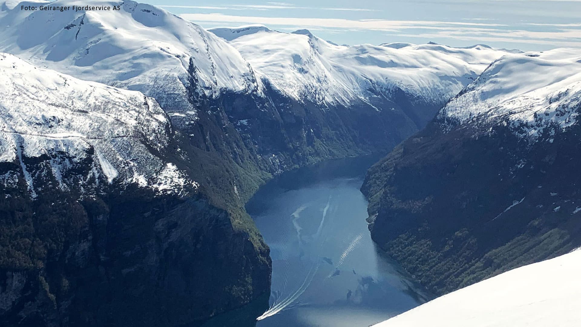 Bilde sett ovenfra i Geirangerfjorden med sightseeingbåt på fjorden