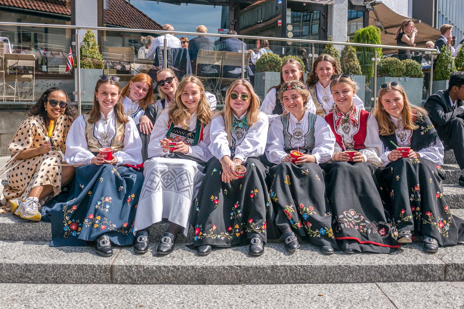 A group of ladies in national costume sitting on a staircase