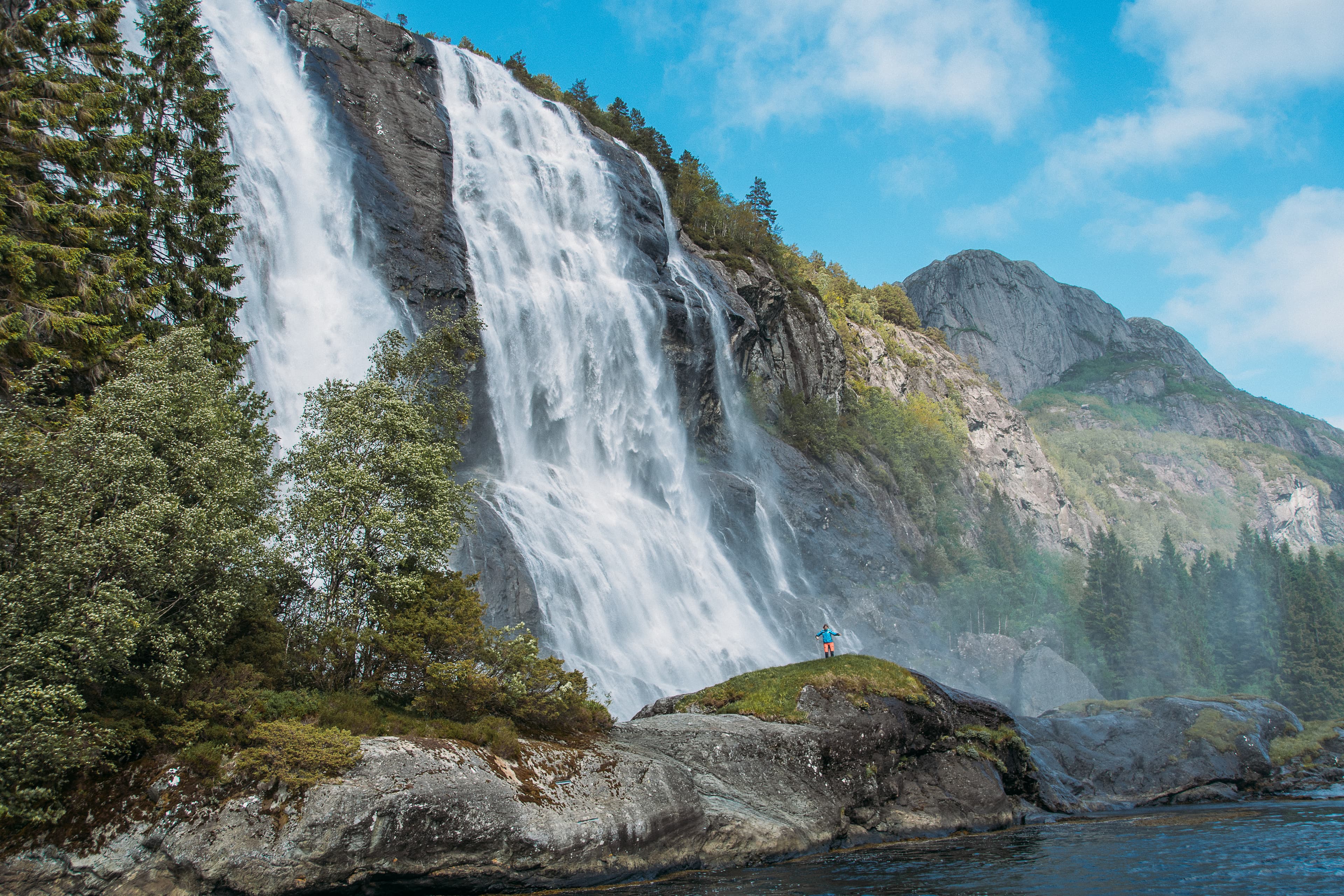 Foss, natur og person som står nær fossen