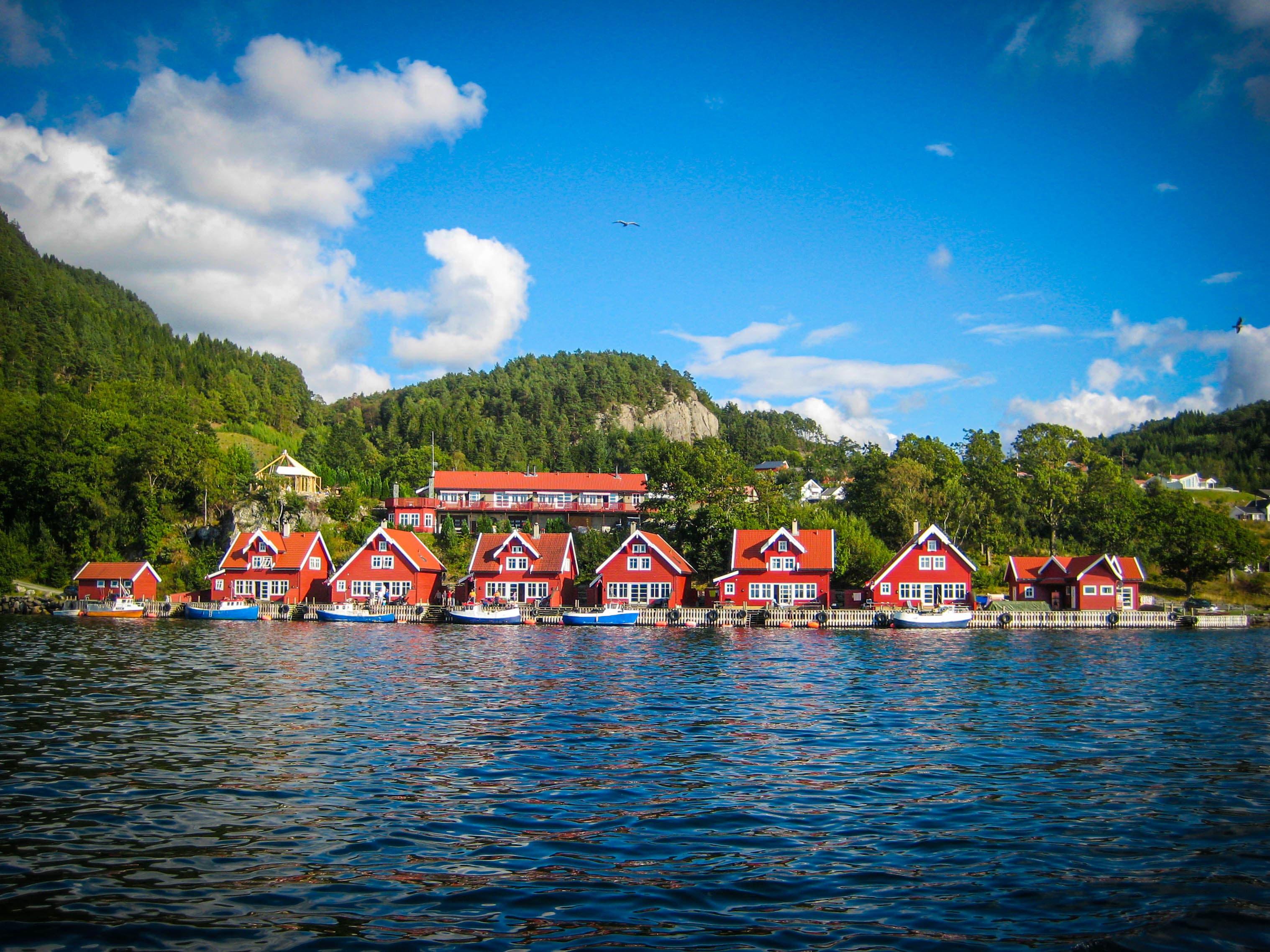 En rekke røde leiligheter, sett fra fjorden.