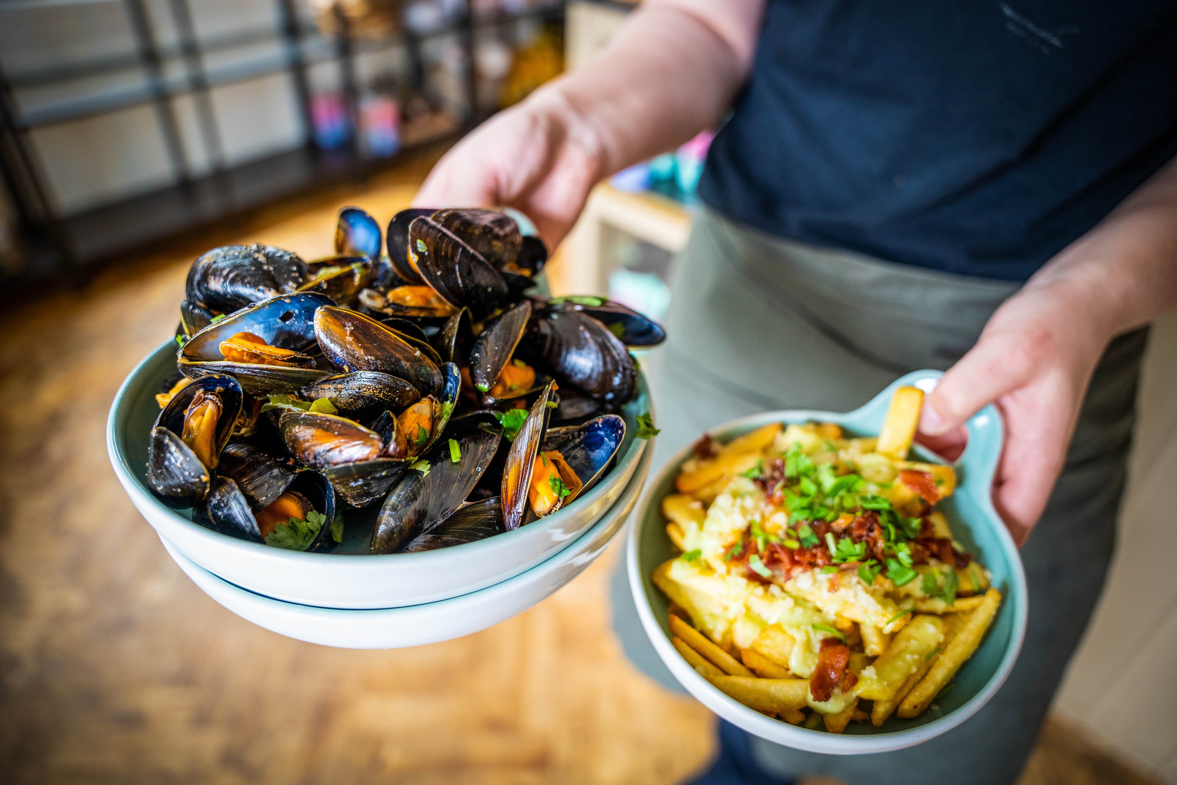 En skål med blåskjell og en skål med dirty fries.