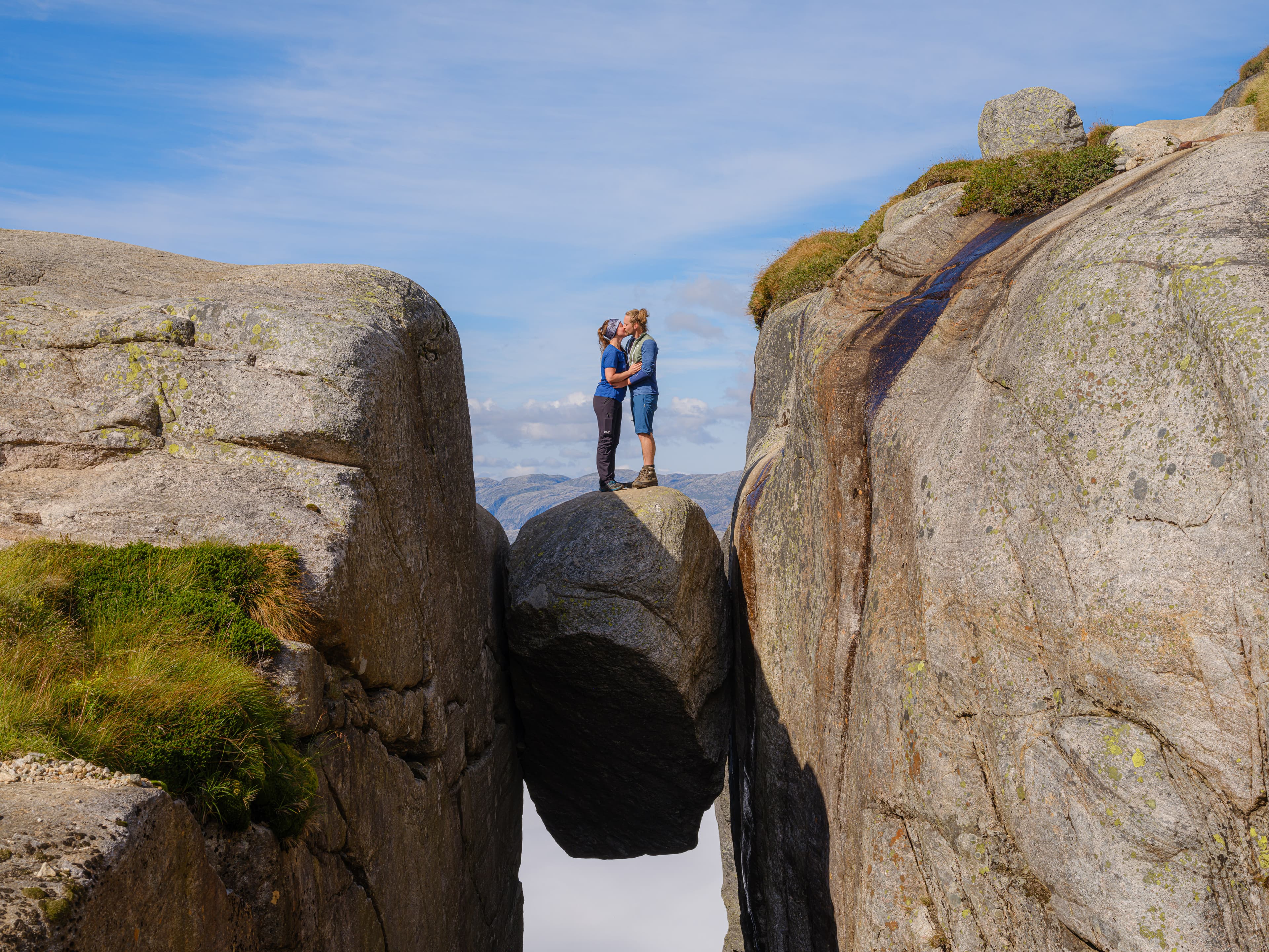 par som kysser på toppen av Kjeragbolten.