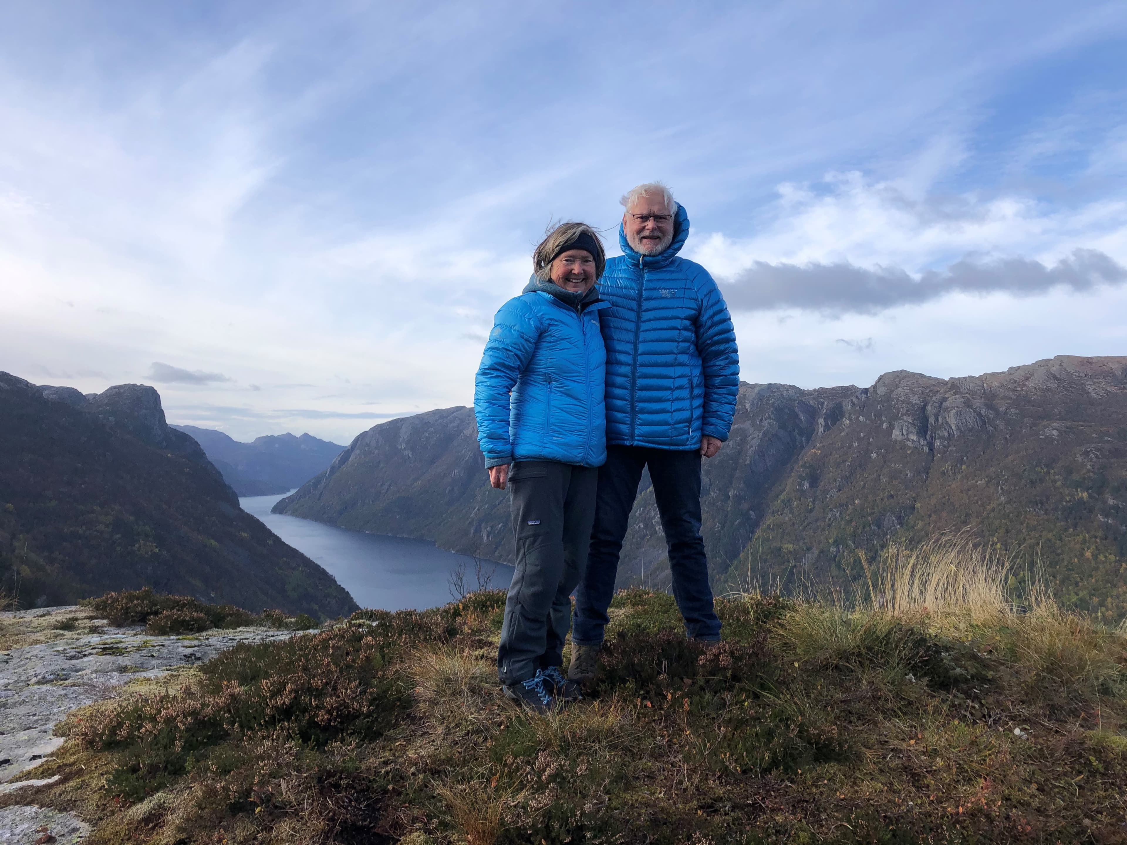 Par på fjelltopp med fjorden i bakgrunnen