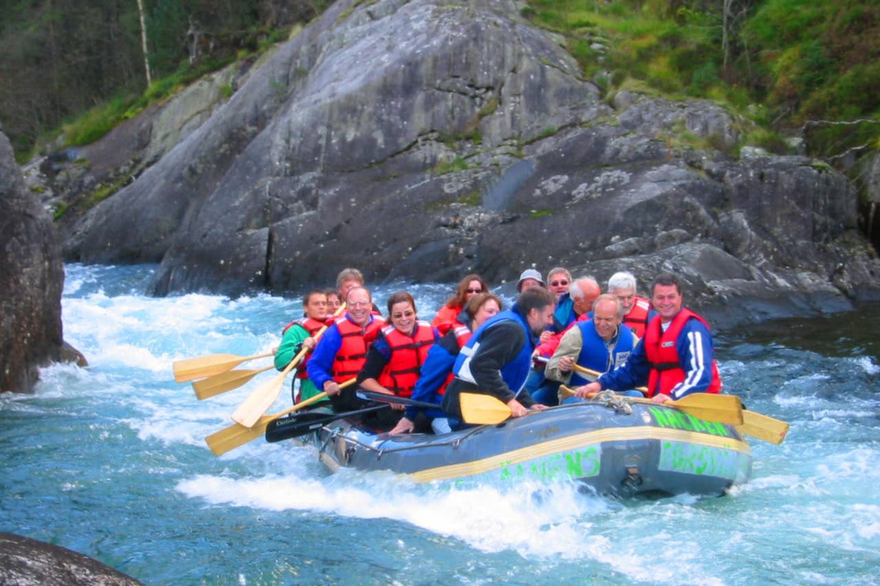 Flere personer som rafter i en gummibåt ned Suldalslågen.