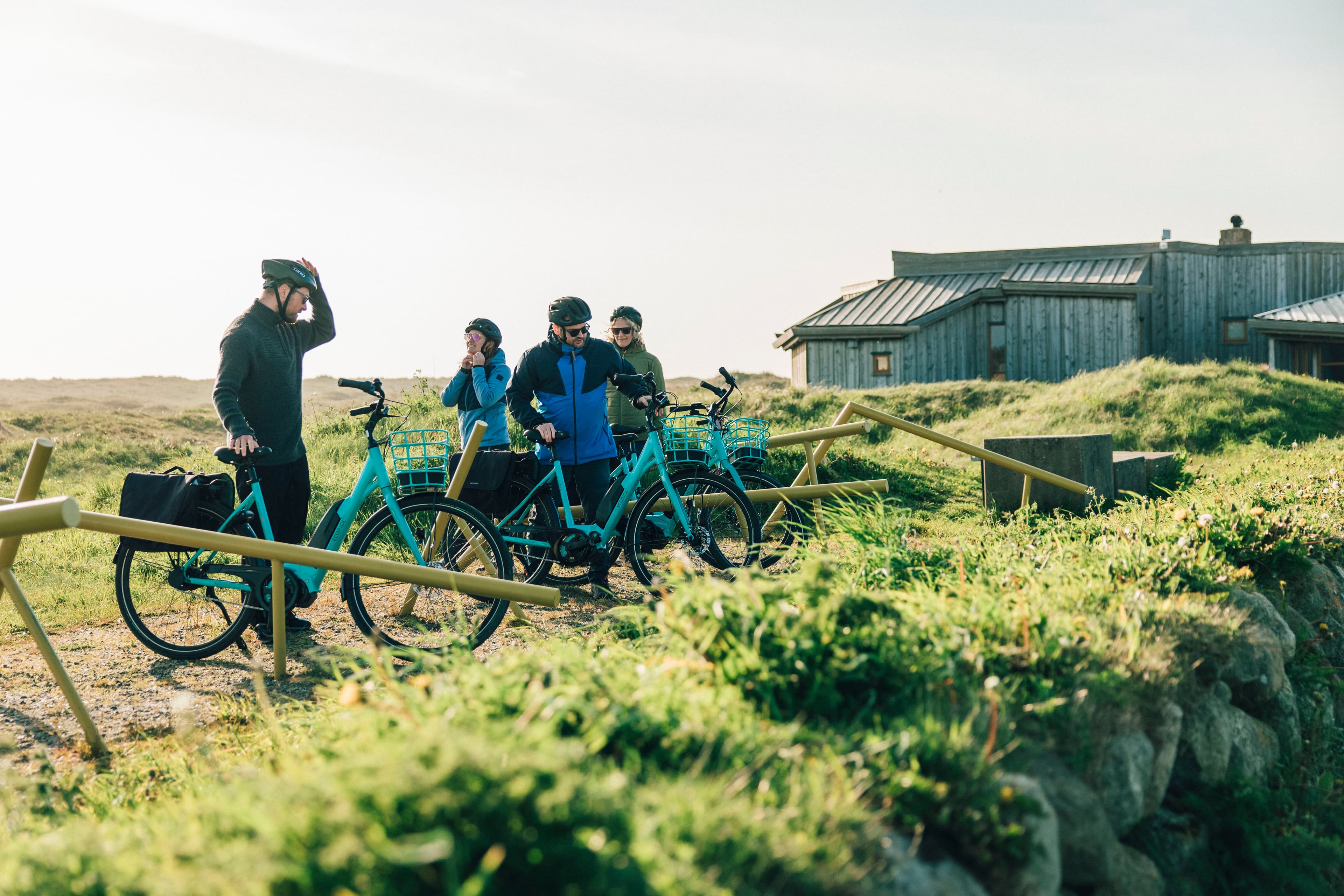 Fire personer parkerer sykler utenfor Friluftshuset på Orre