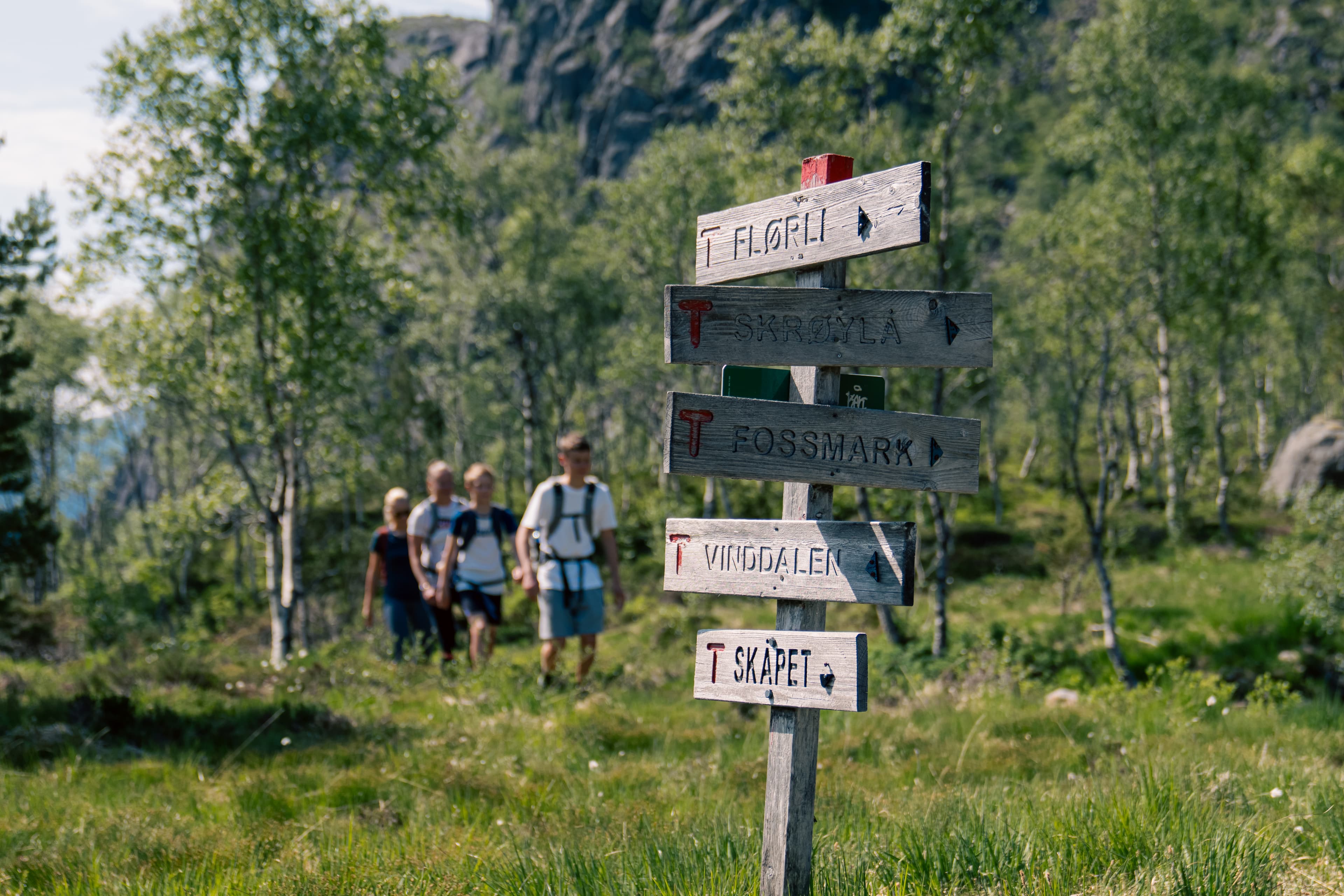 En familie som går på en sti i fjellterreng
