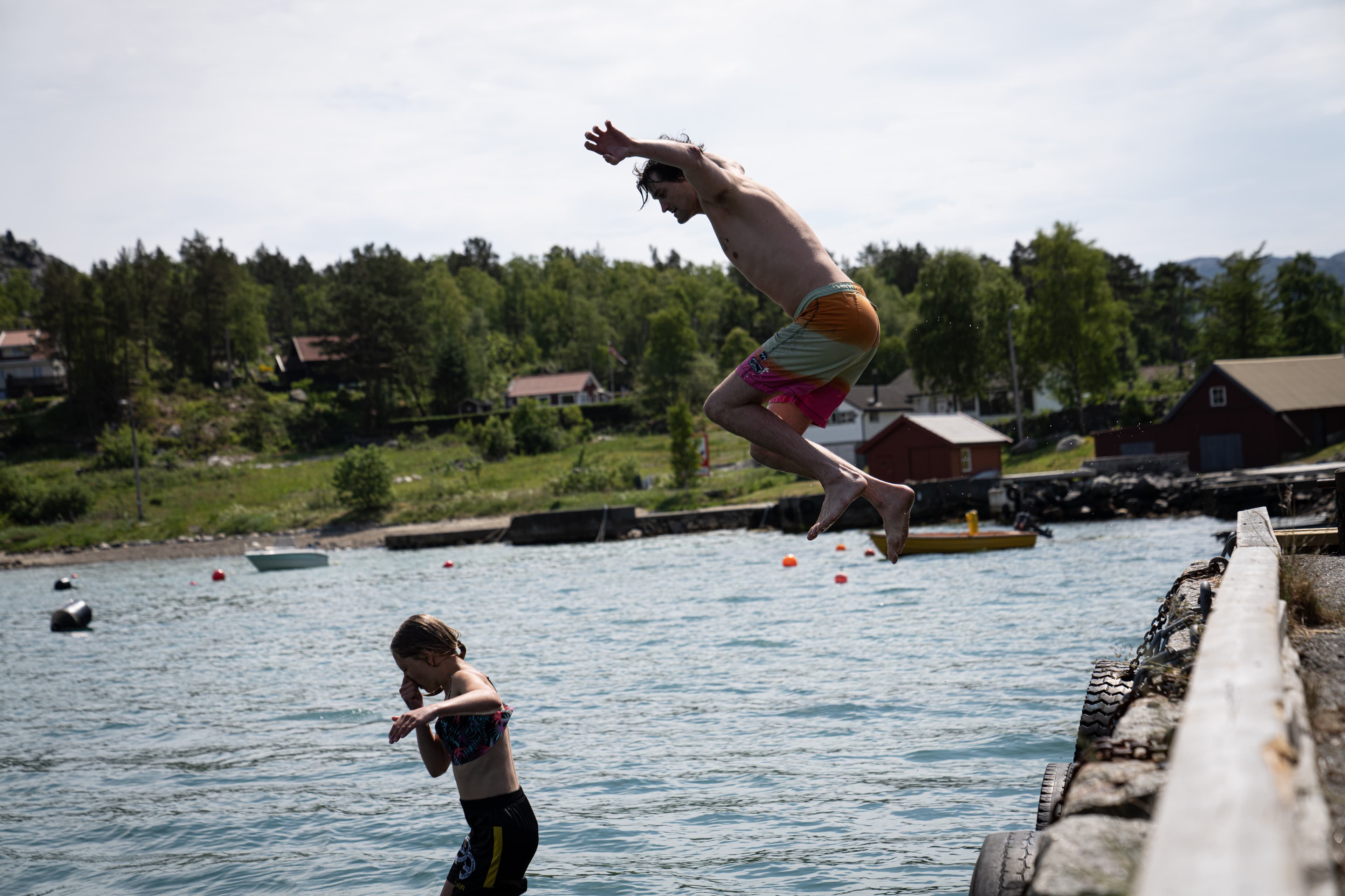 To gutter hopper i vannet fra en brygge