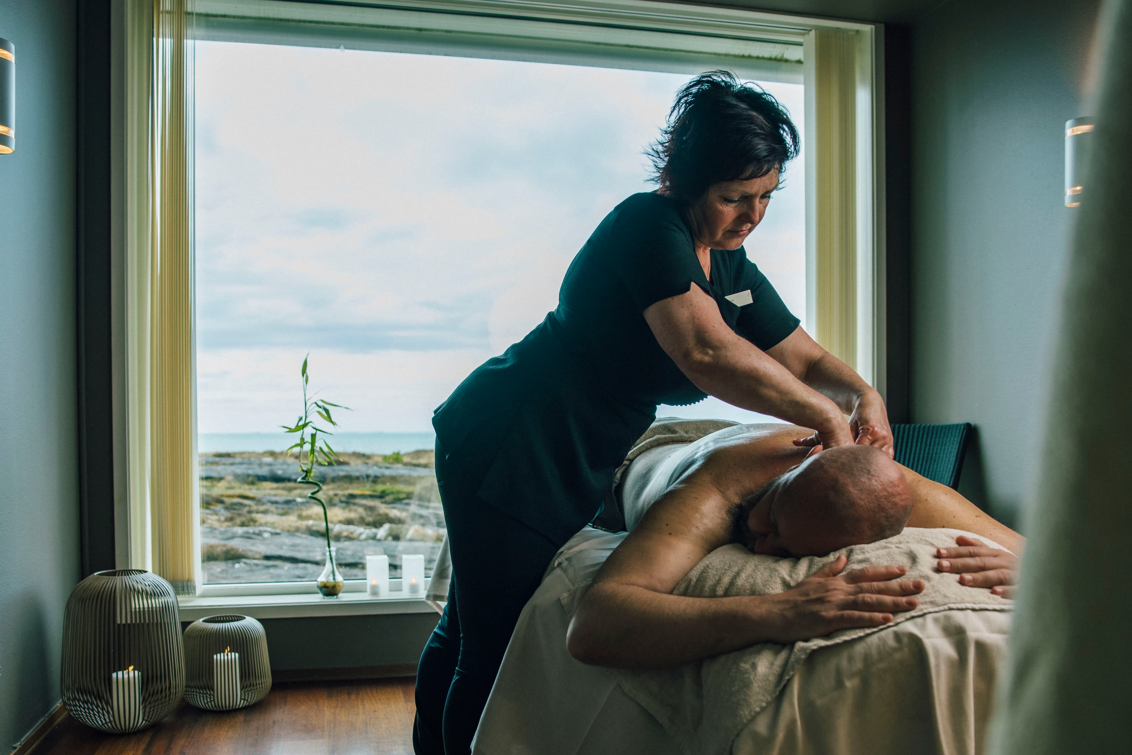 Woman giving massage to a man at the Sola Strand Spa