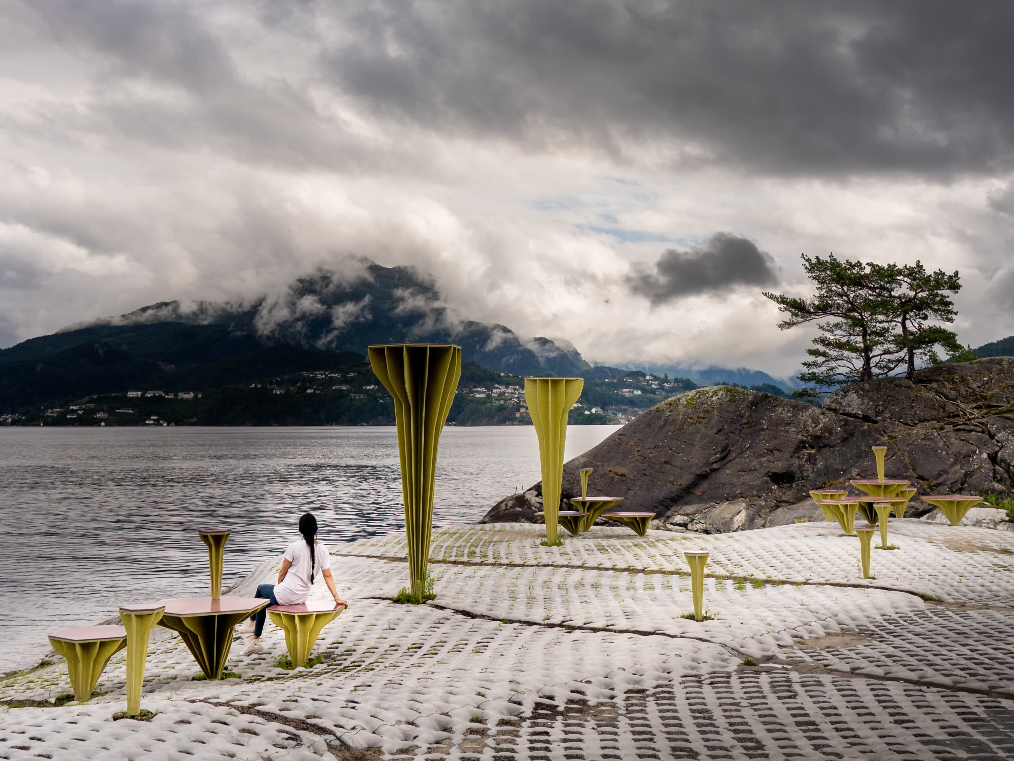 En dame som sitter på de gule benkene.