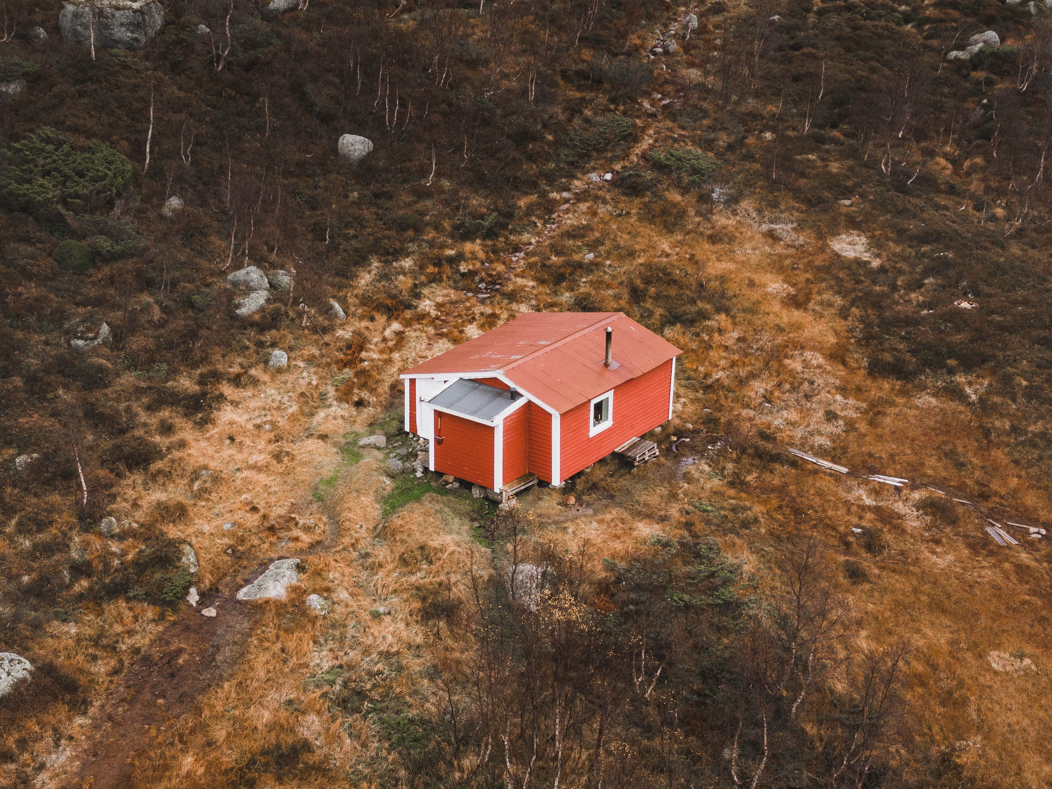 En rød hytte i skogen.