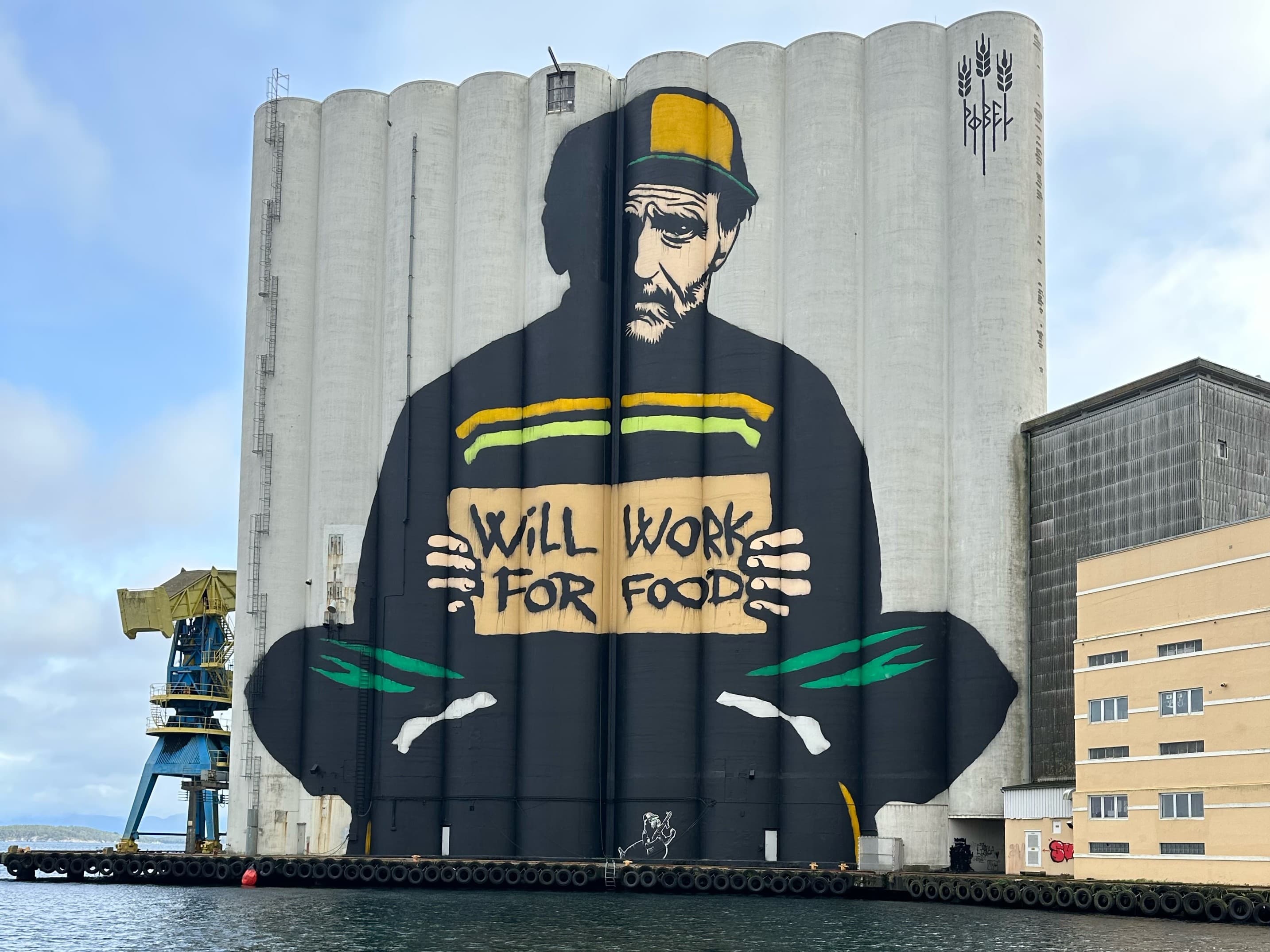 Street art work painted on large silos. Name of the artwork: Will work for food - Pøbel