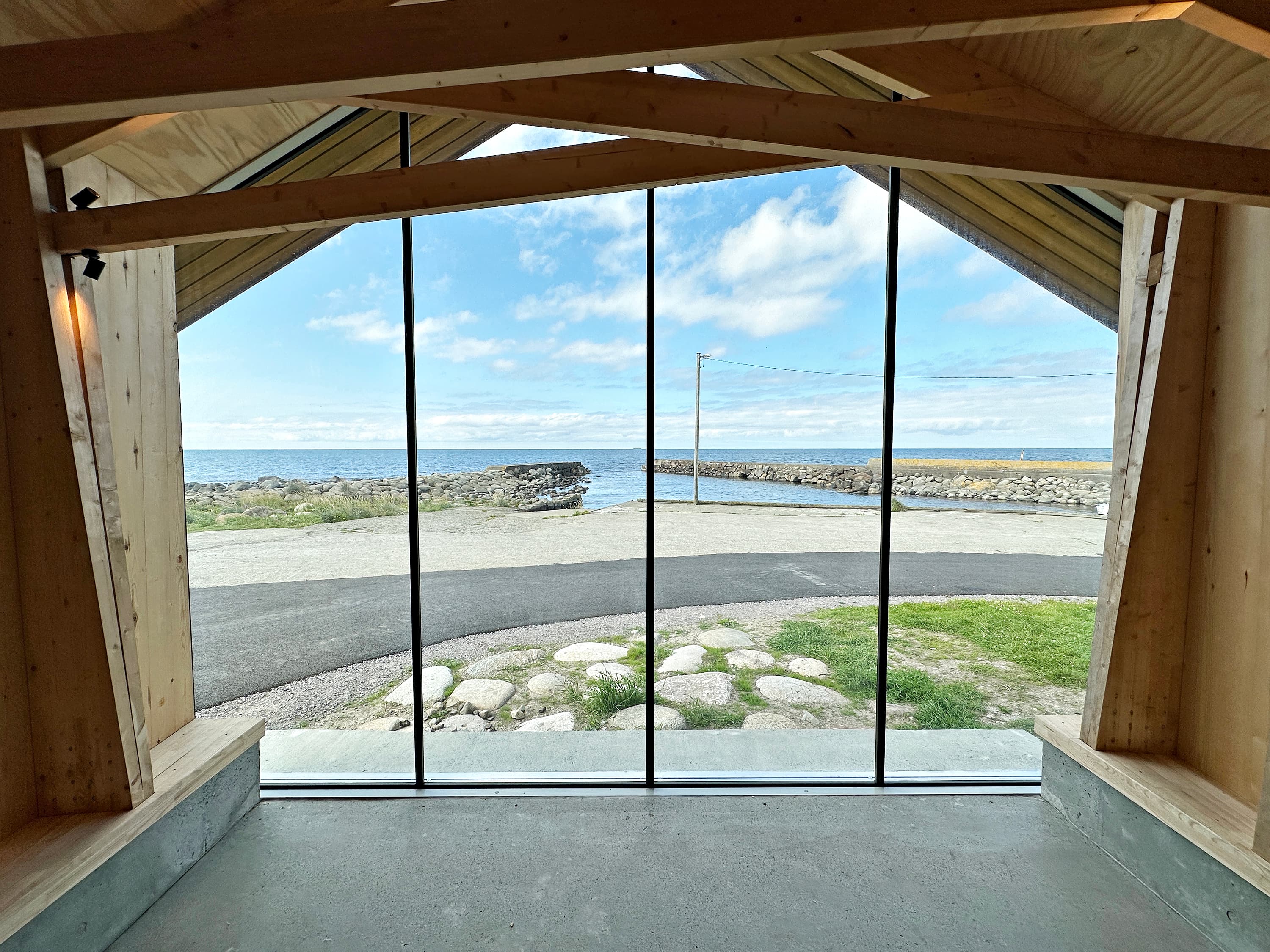 View from inside a storm shelter at the madland harbour. View through large glass windows towards the ocean.