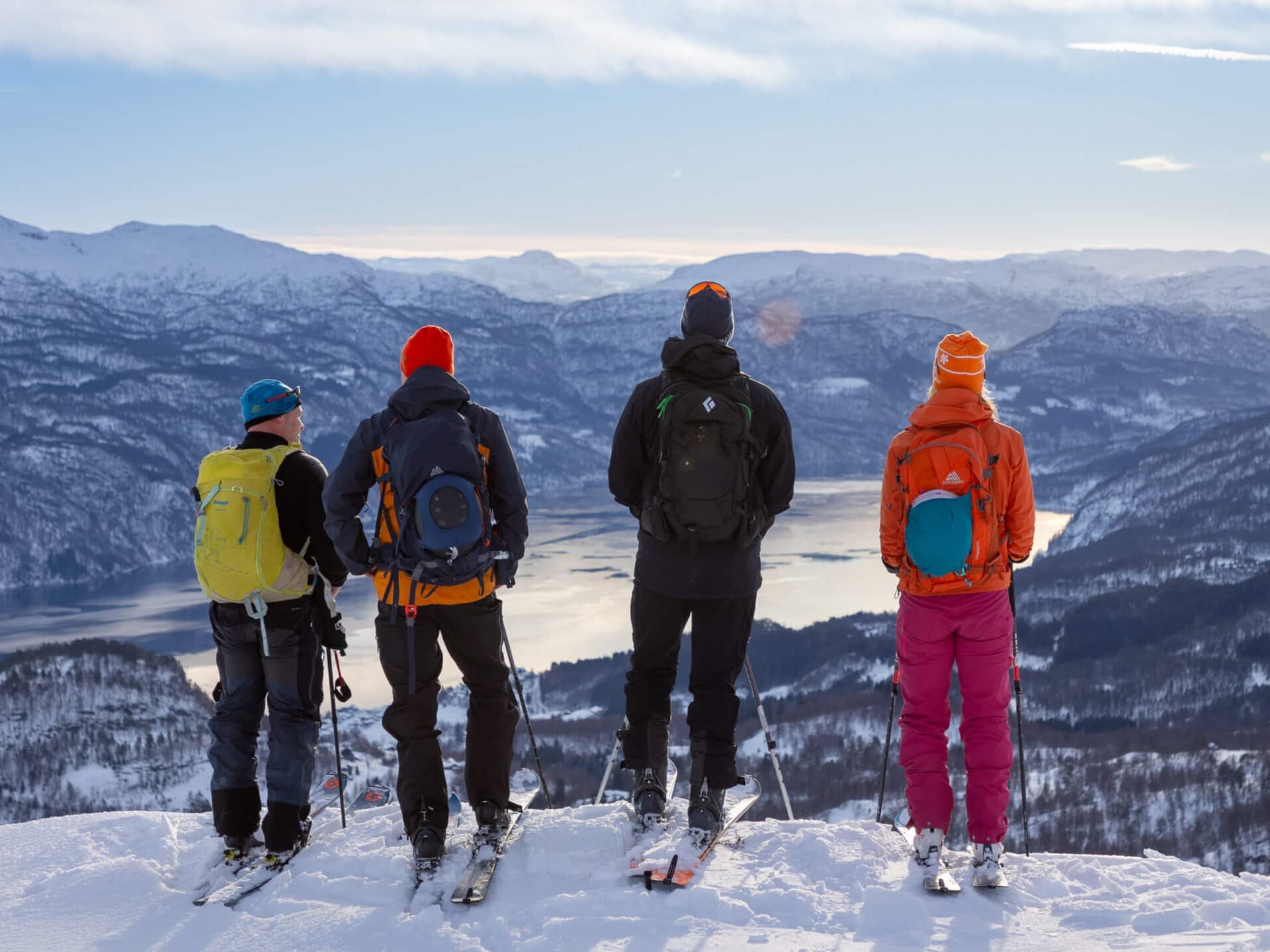 Fire personer på ski som nyter utsikten over Saudafjorden.