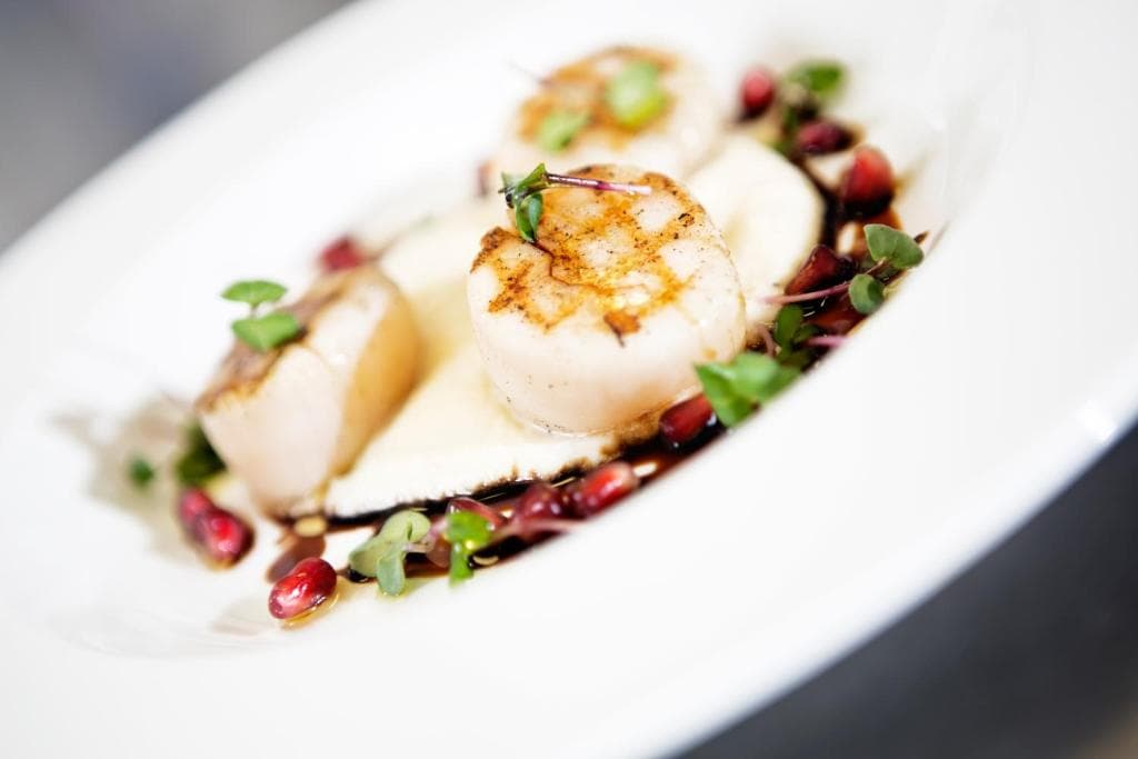 Food plates, kitchen staff, hotel restaurant, set table with white tablecloth, wine glasses on table