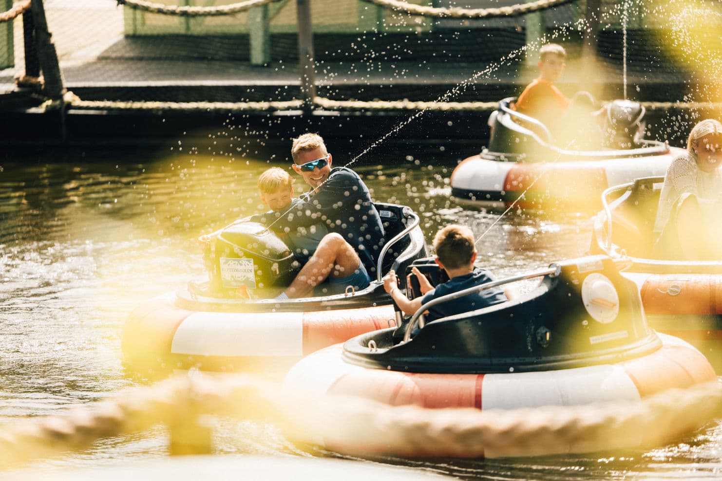 family enjoying themselves in different rides at an amusement park
