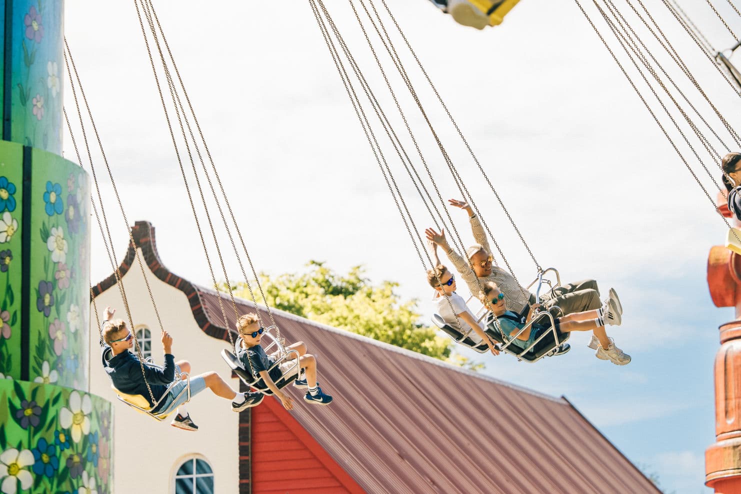 family enjoying themselves in different rides at an amusement park