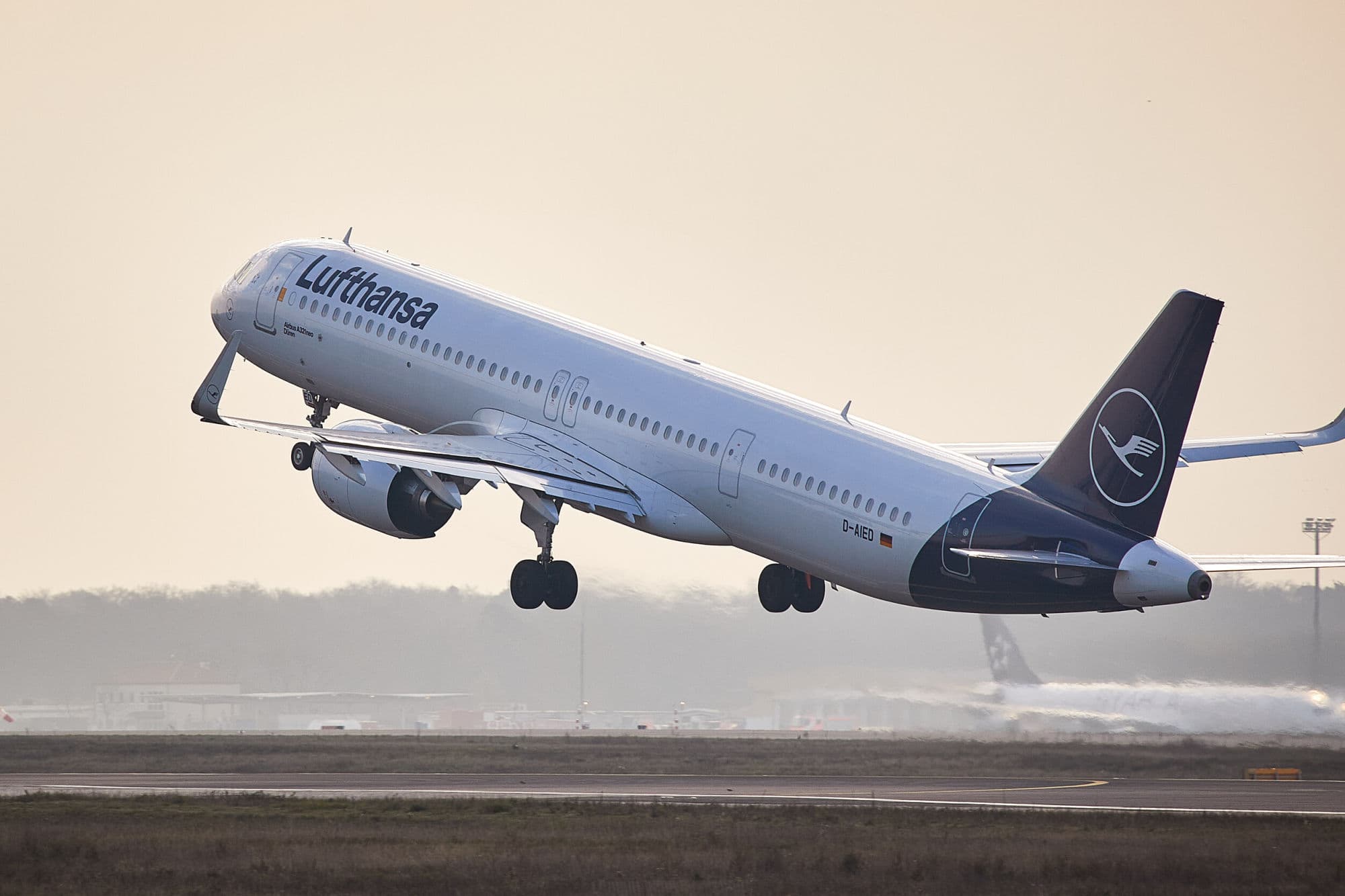 Airplane in the air with Lufthansa written on it in blue