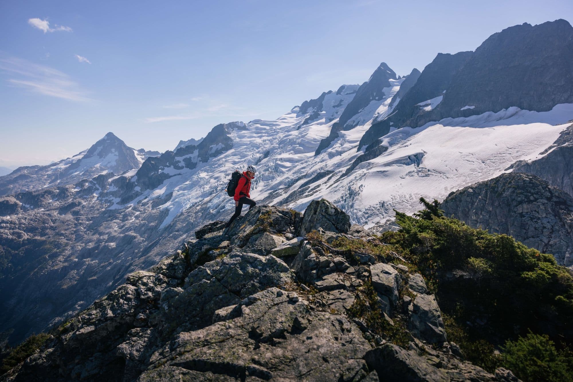 Man hiking in snowcapped mountains with Helly Hansen clothing on. Helly Hansen outdoor norwegian clothing for norwegian conditions. Norwegian shopping.