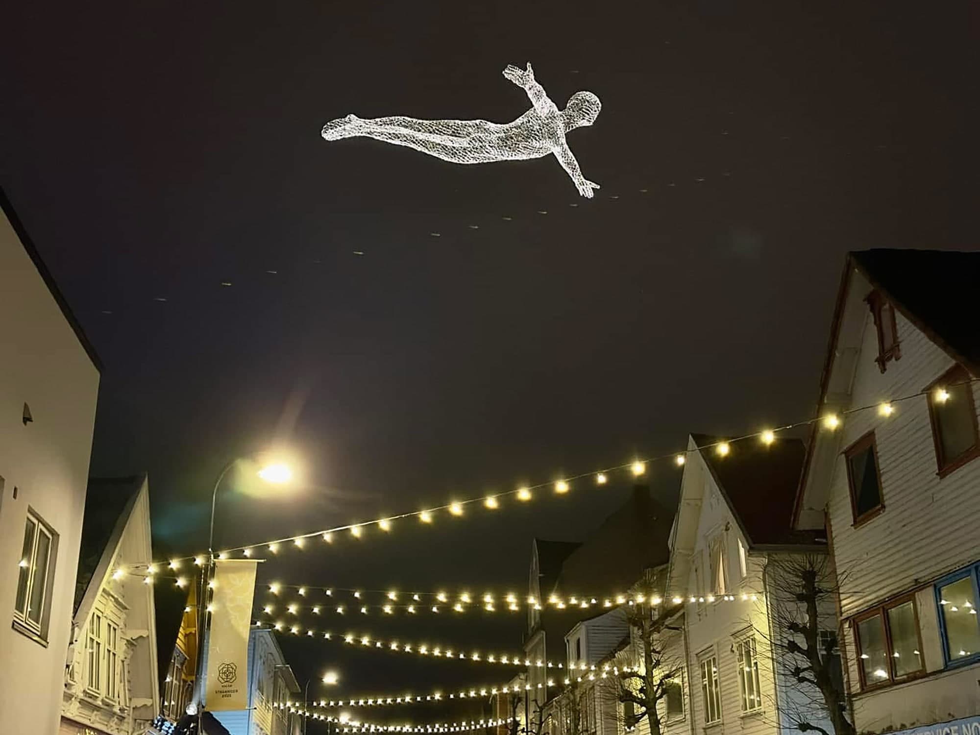 light sculptures shaped like a man hanging above popular street in Stavanger