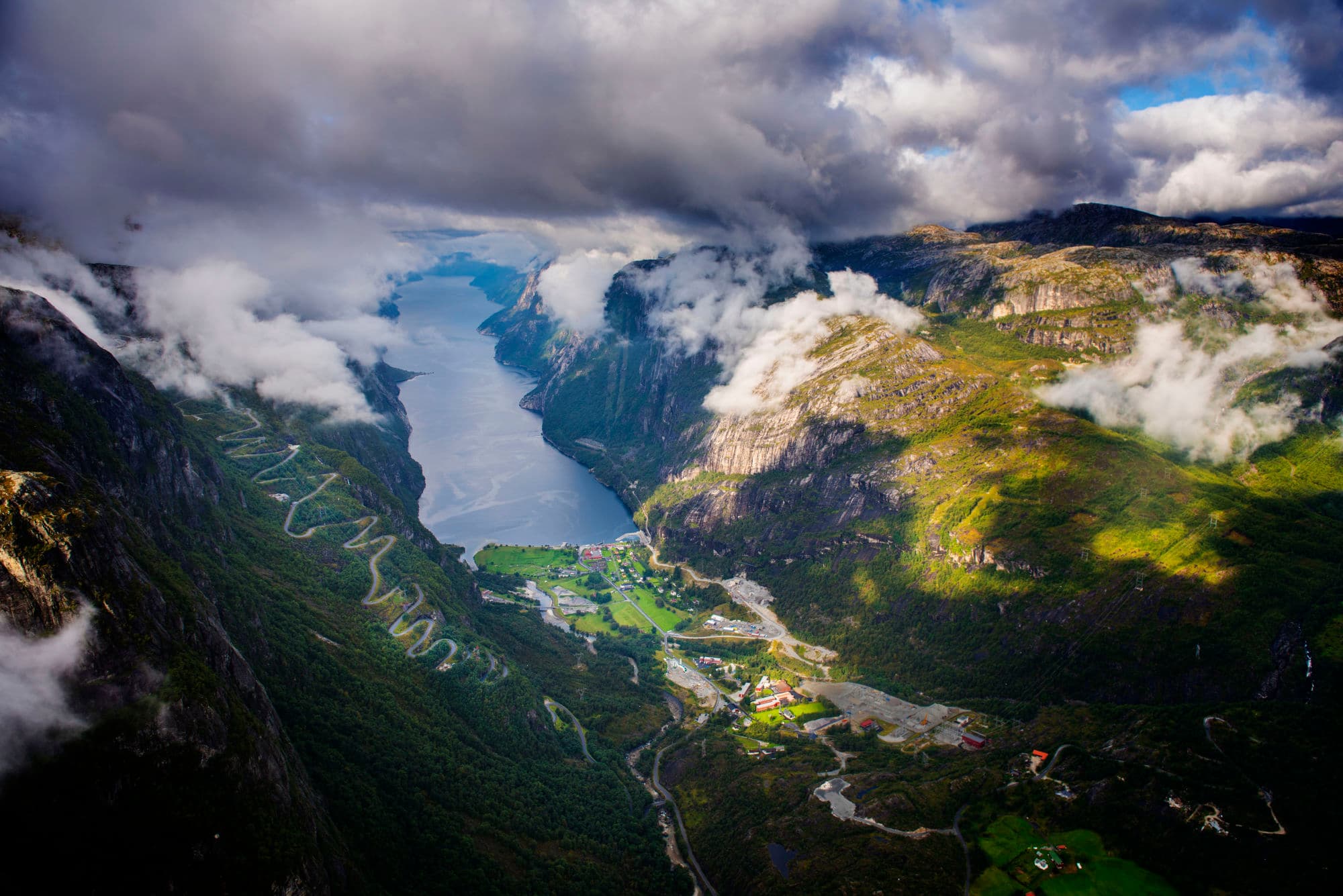 Hairpin road seen from above with mountain and fjord views