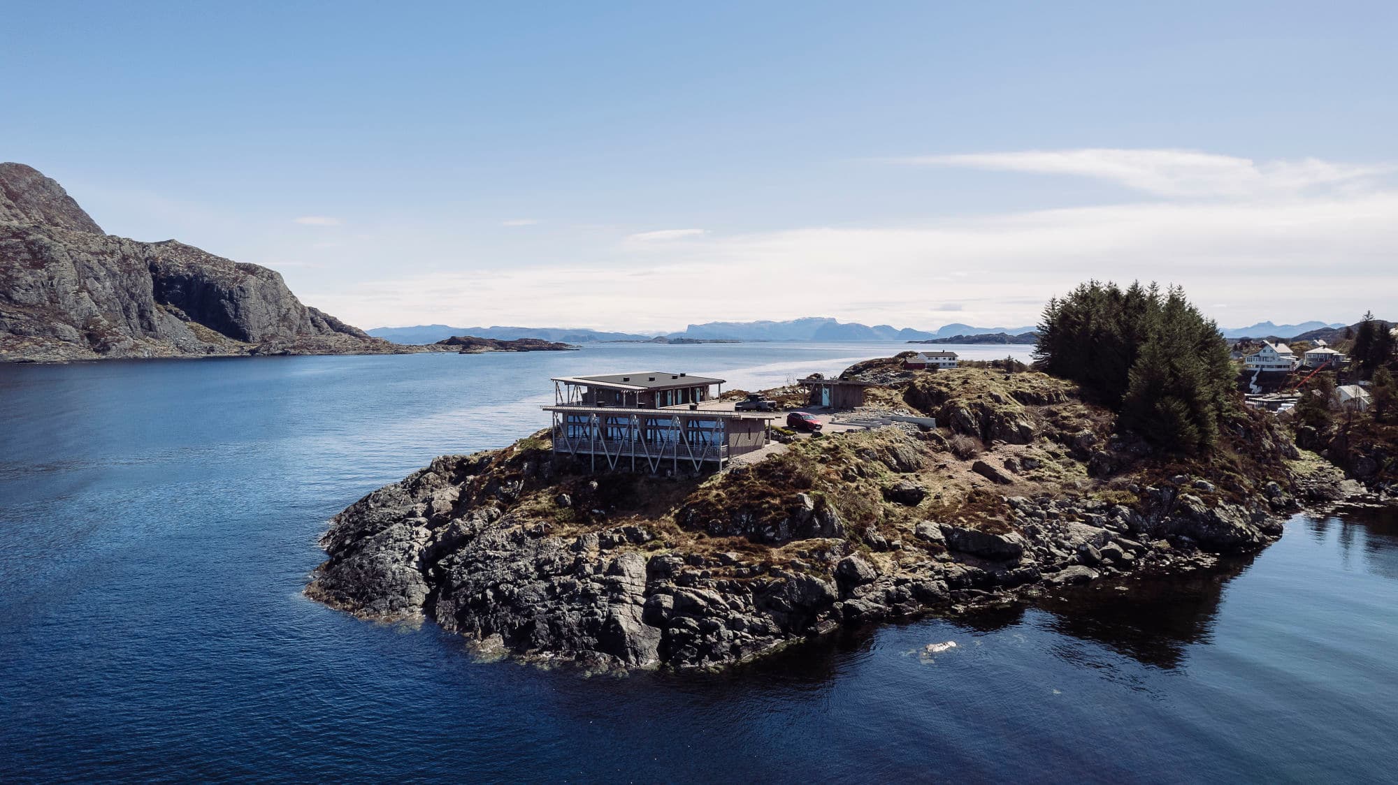 Dronebilete av havhotellet. Det er to bygg der alle romma er vendt mot sjøen. Hotellet ligg ute på ein odde og det er berre nokre meter frå sjøen.