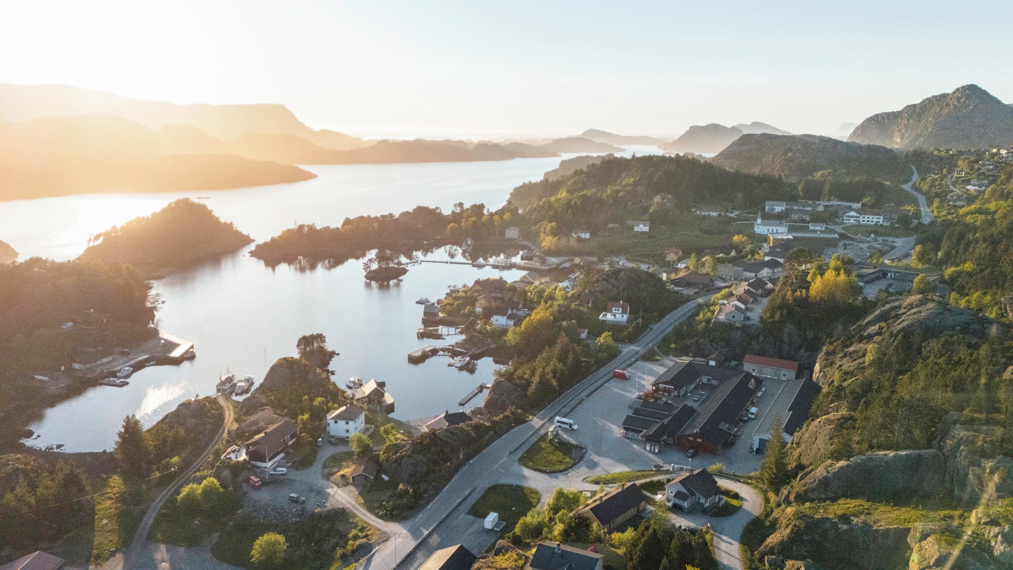 Dronebilde av eit kommunesenter, eit landskap. det er solnedgang