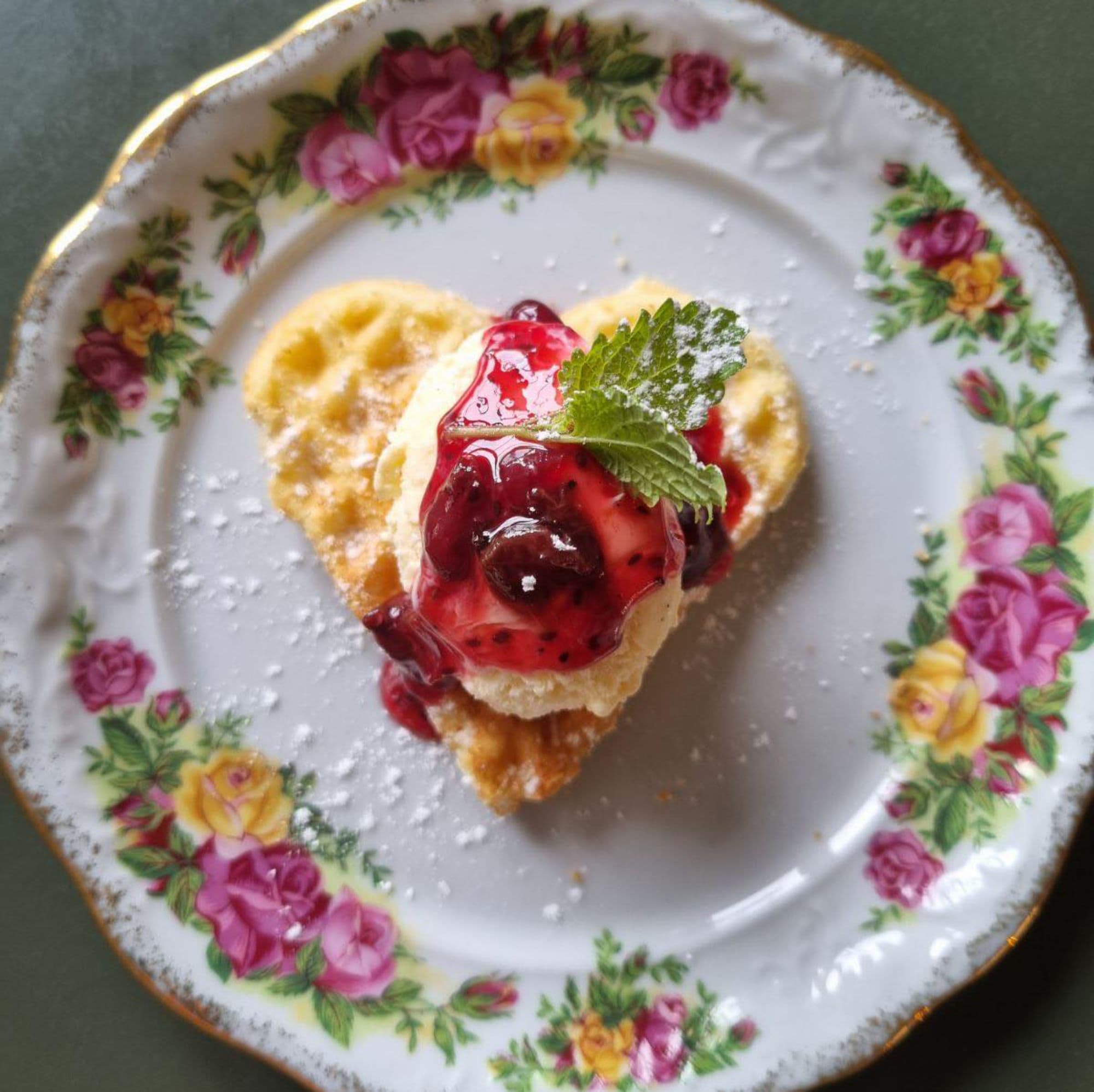 A waffle heart on a flowery plate with jam at cafe No 18 Kulturkafé