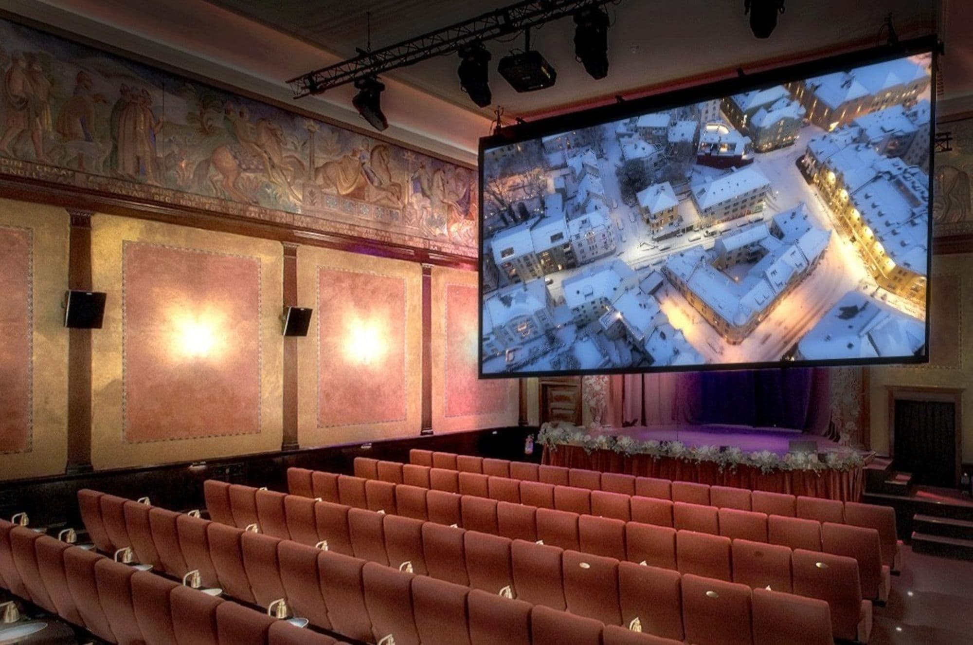 Lun stemning inne på Løvenvold Theater med stoler og lerret.