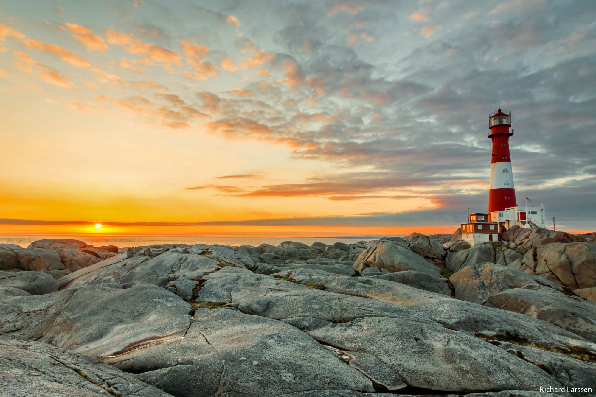 Eigerøy fyr in sunset with moonlike rocks surrounding it