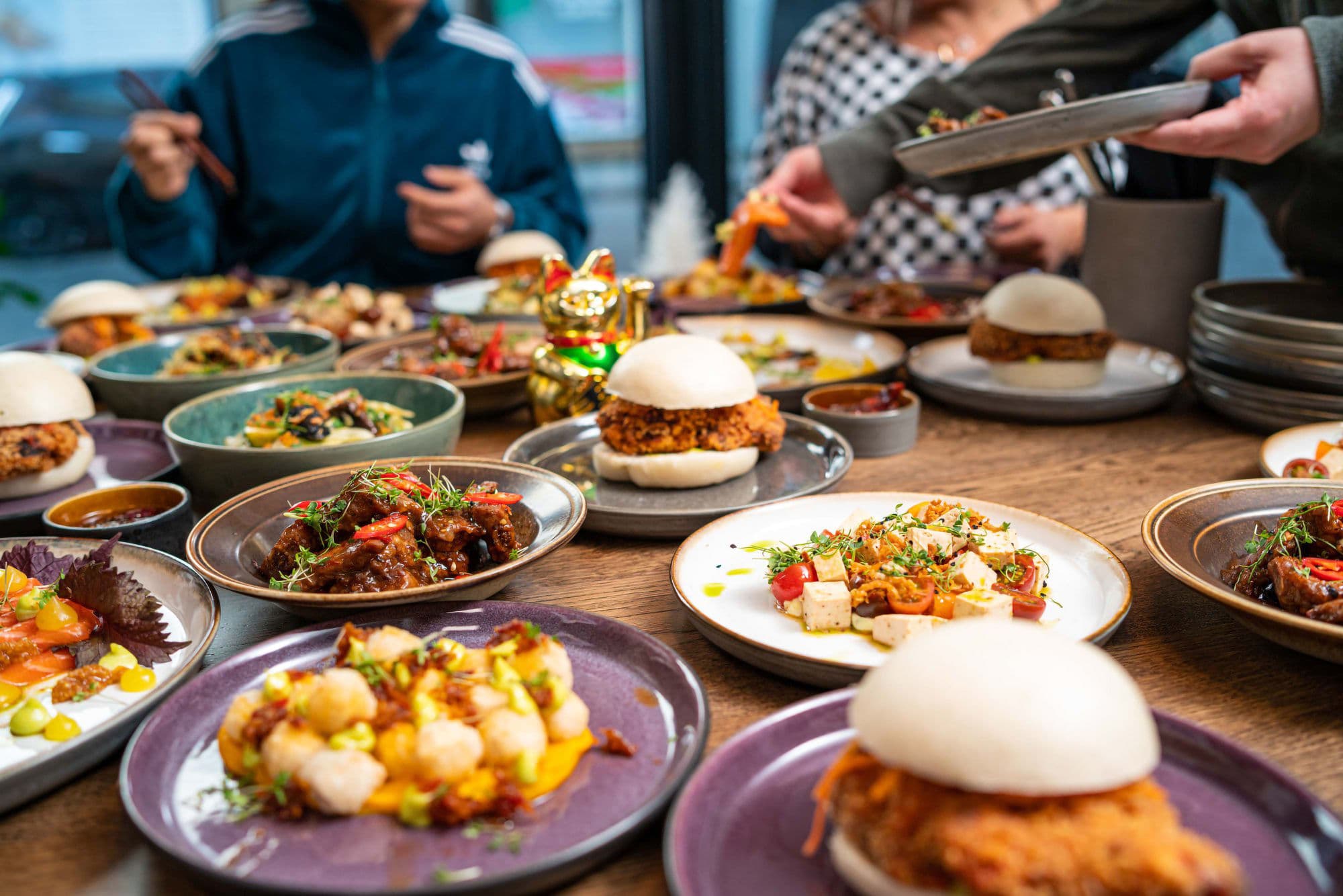 food stall with lots of plates of food, and people in a street