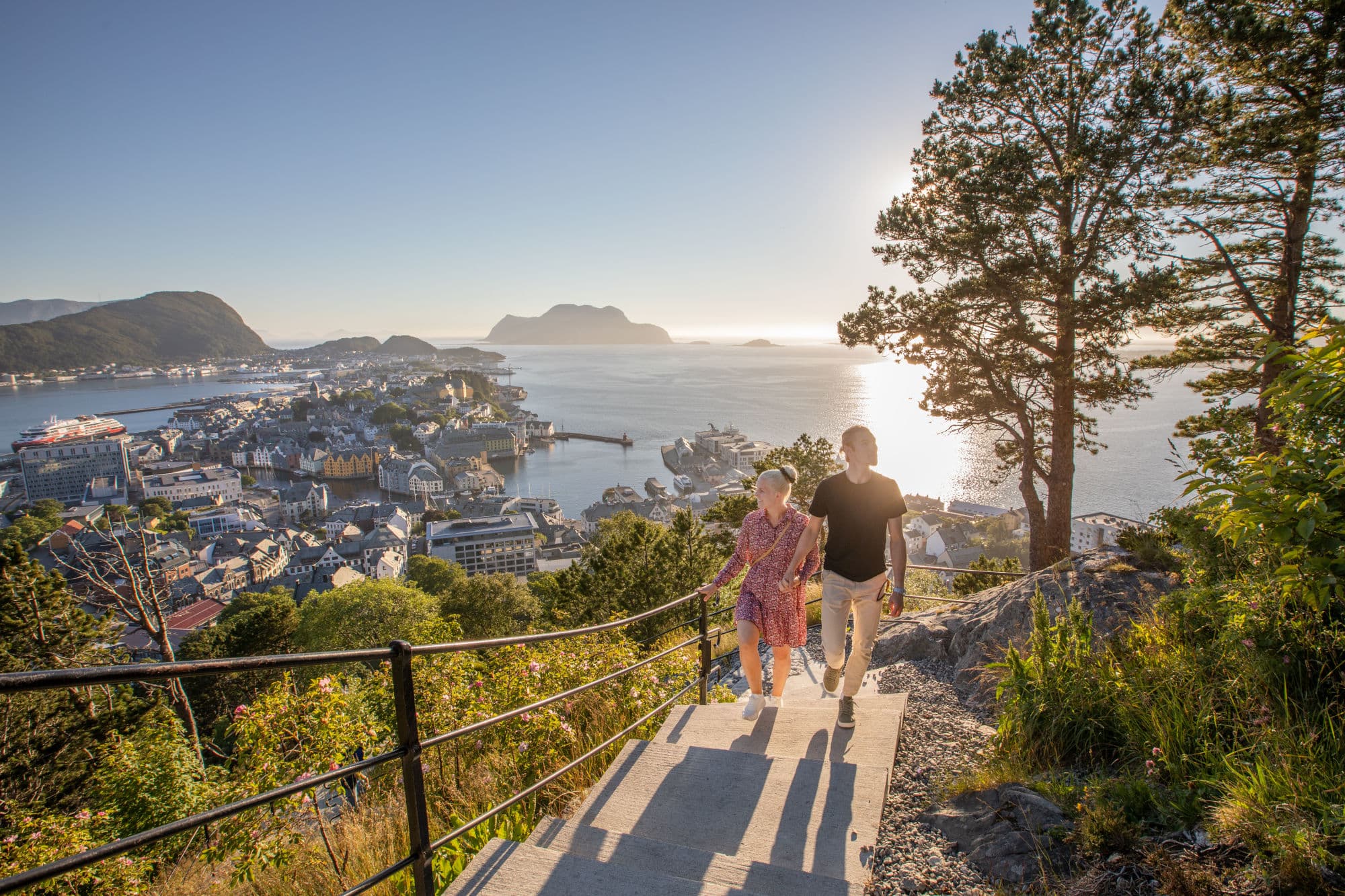 To personer går trappene til Aksla i solnedgang