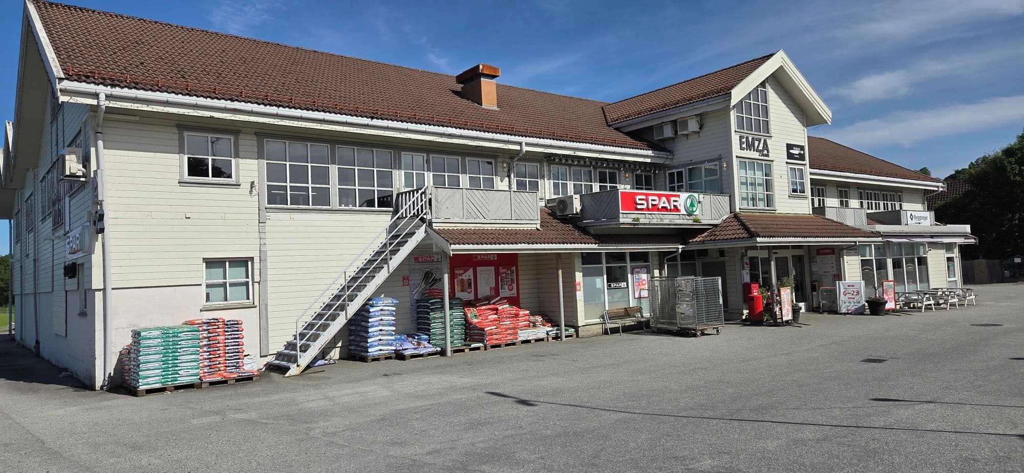 Foto av næringsbygg med skilt til blant anna Spar på utsida