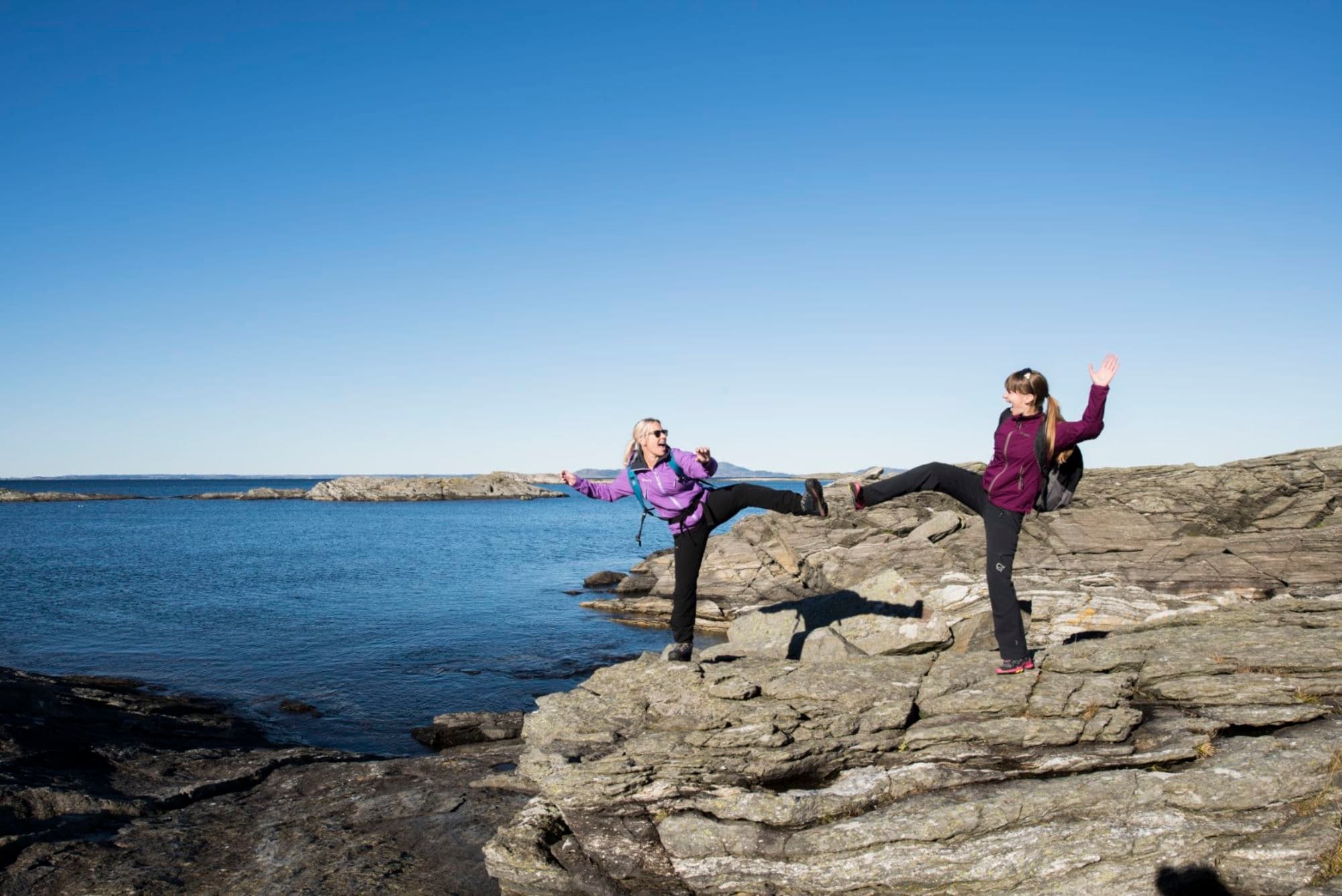 Two women hiking along the shores of Fjøløy